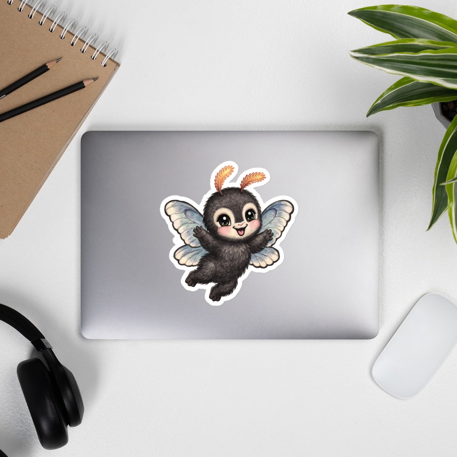 Baby Mothman, from Cinderpoint's Storybook Cryptids graces the top of a laptop in its 6"x8" size removable, durable, vinyl decal.