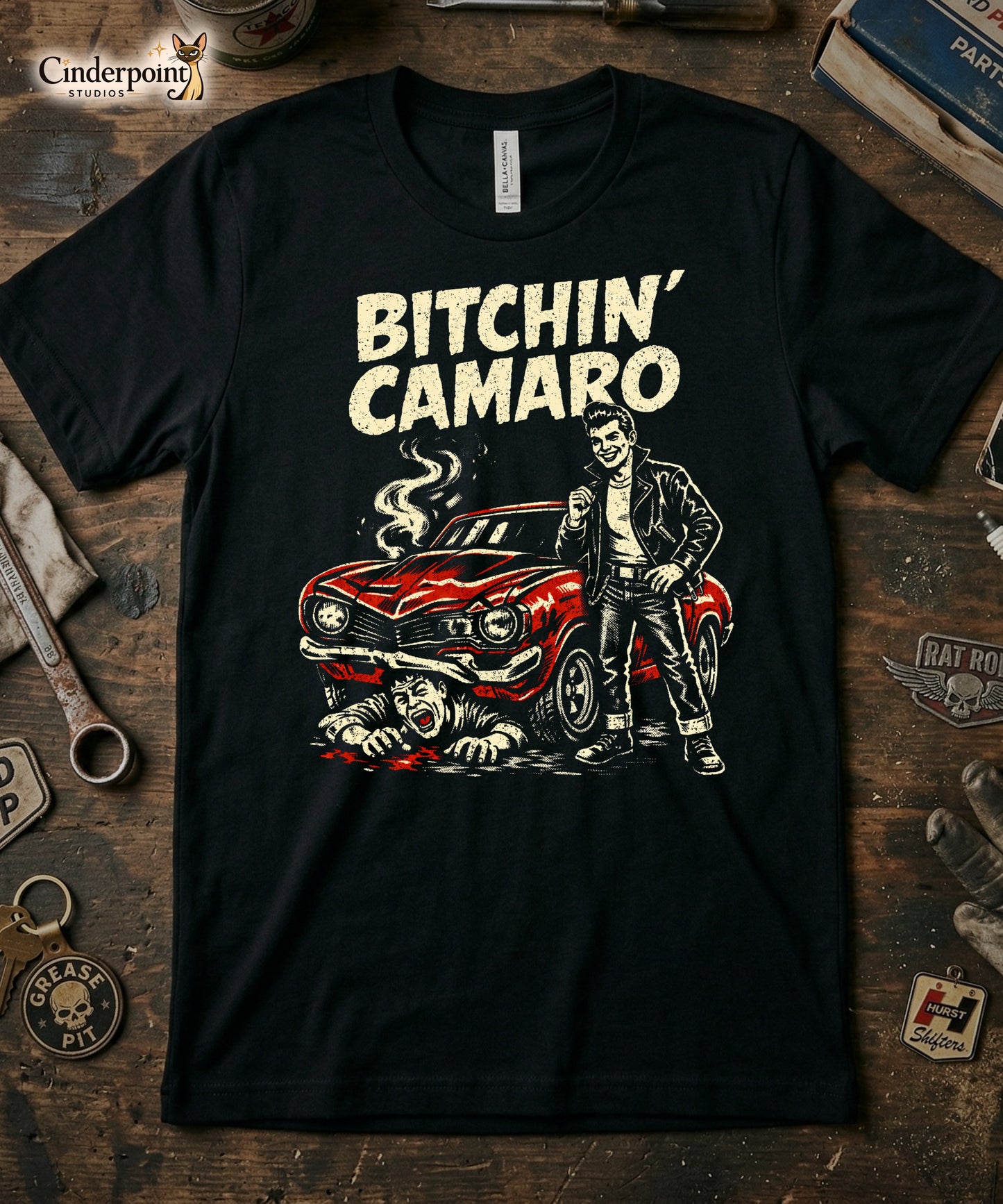 A retro-style graphic t-shirt featuring a stylized vintage Camaro muscle car with "Bitchin Camaro" in bold, distressed punk-rock lettering.