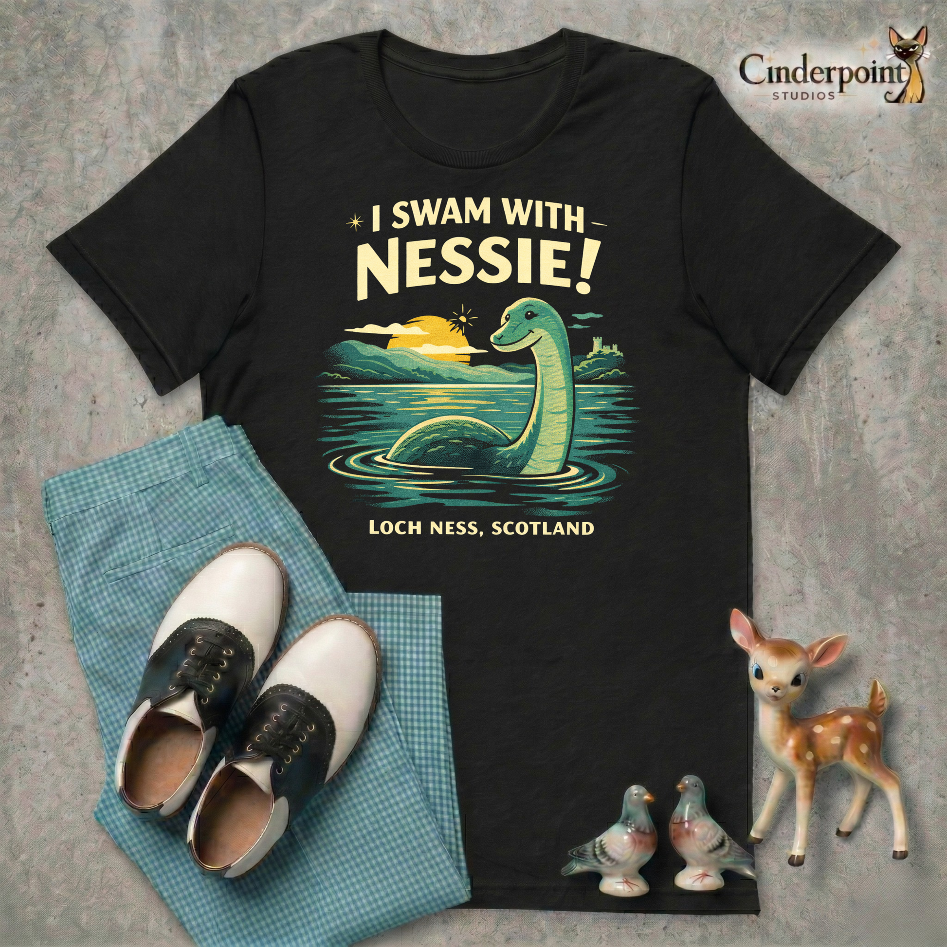A retro cryptid travel t-shirt featuring Nessie in Loch Ness, Scotland with scenic vintage-style artwork and playful souvenir-shirt charm.