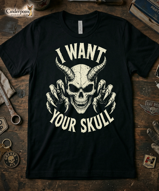 A retro-style graphic on a black t-shirt featuring a detailed horned demon skull with sharp claws and "I WANT YOUR SKULL" in distressed punk-rock lettering.