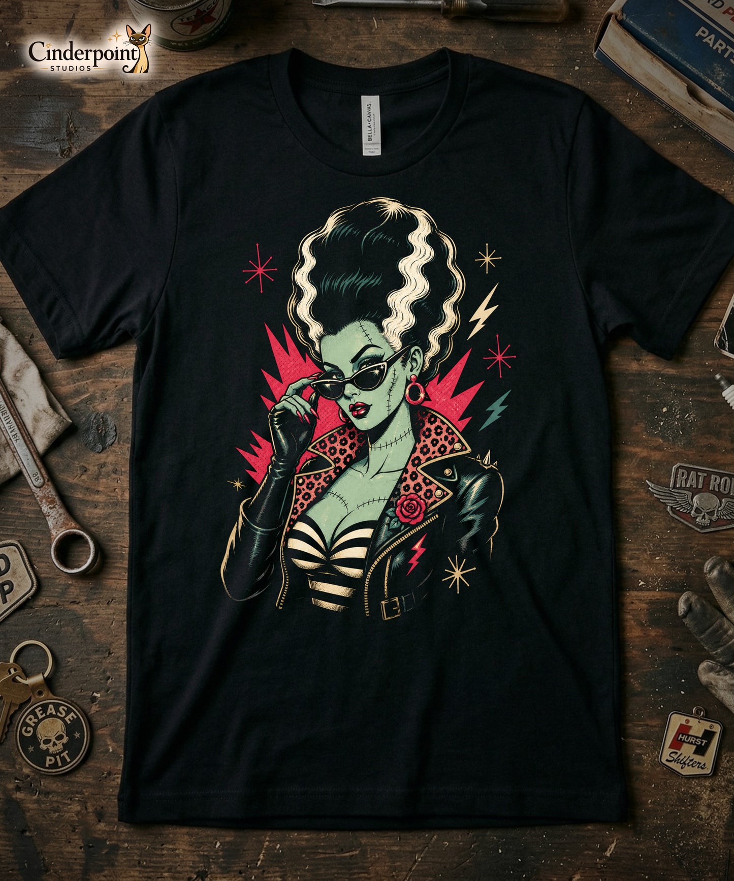 Artistic illustration of a green-skinned monster bride with high-volume black and white hair, cat-eye sunglasses, and a leopard-print lined leather jacket on a black t-shirt.