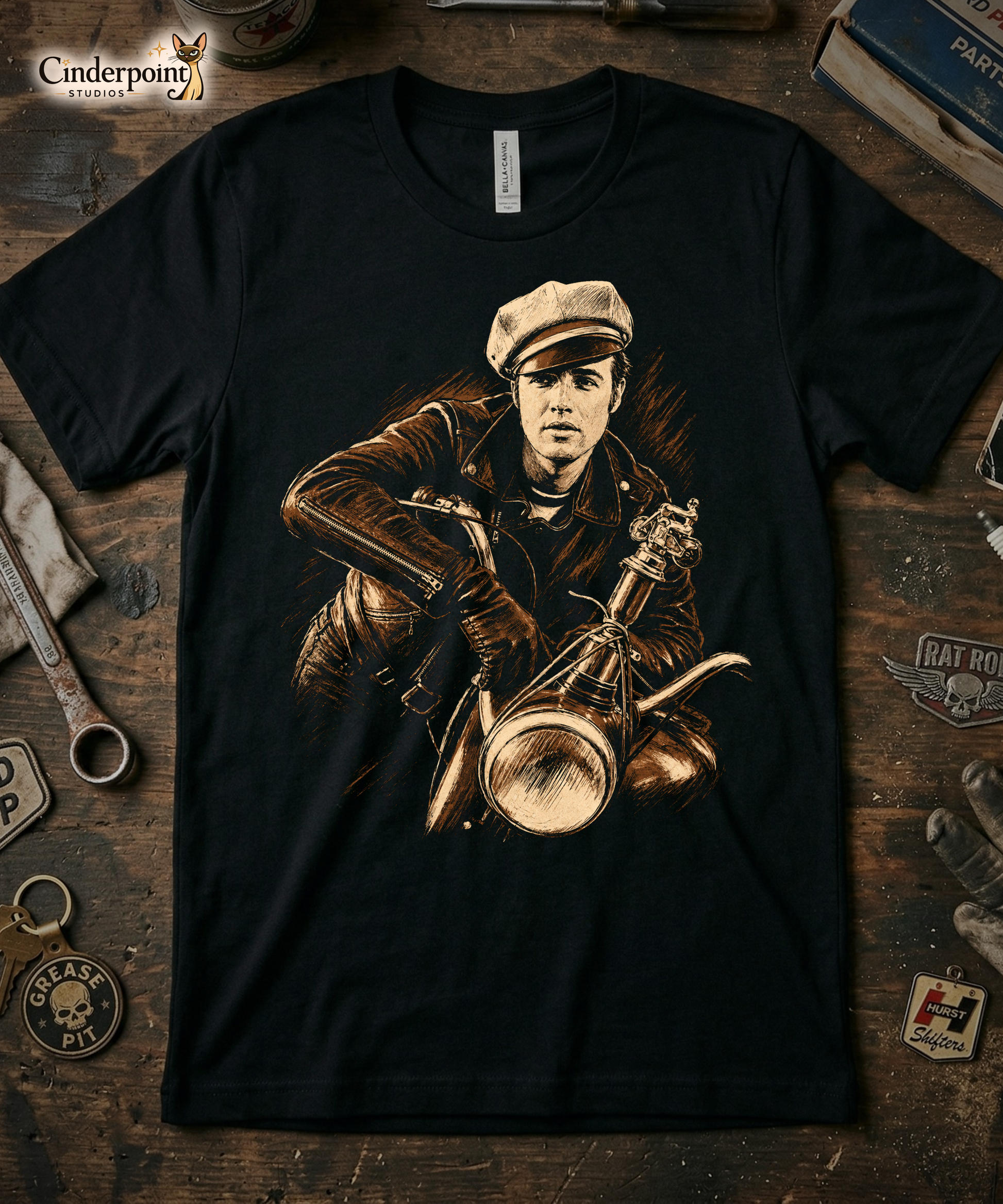 A high-contrast artistic portrait of Marlon Brando as Johnny from The Wild One on a black t-shirt, featuring his iconic tilted biker cap and leather jacket.