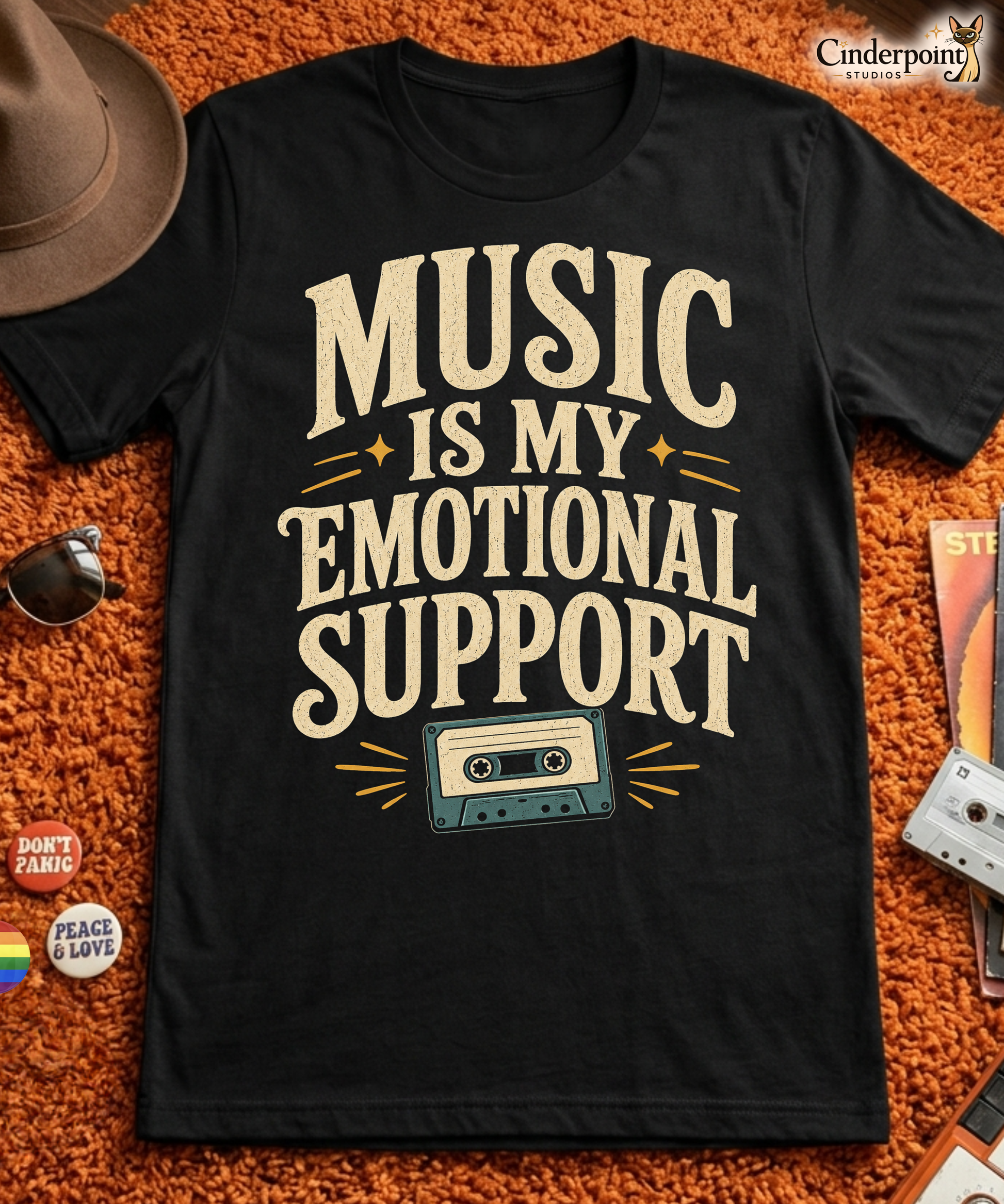 Black graphic tee featuring original Cinderpoint Studios artwork for Music Is My Emotional Support, a retro music lover design with bold vintage lettering, star accents, and a cassette tape illustration.