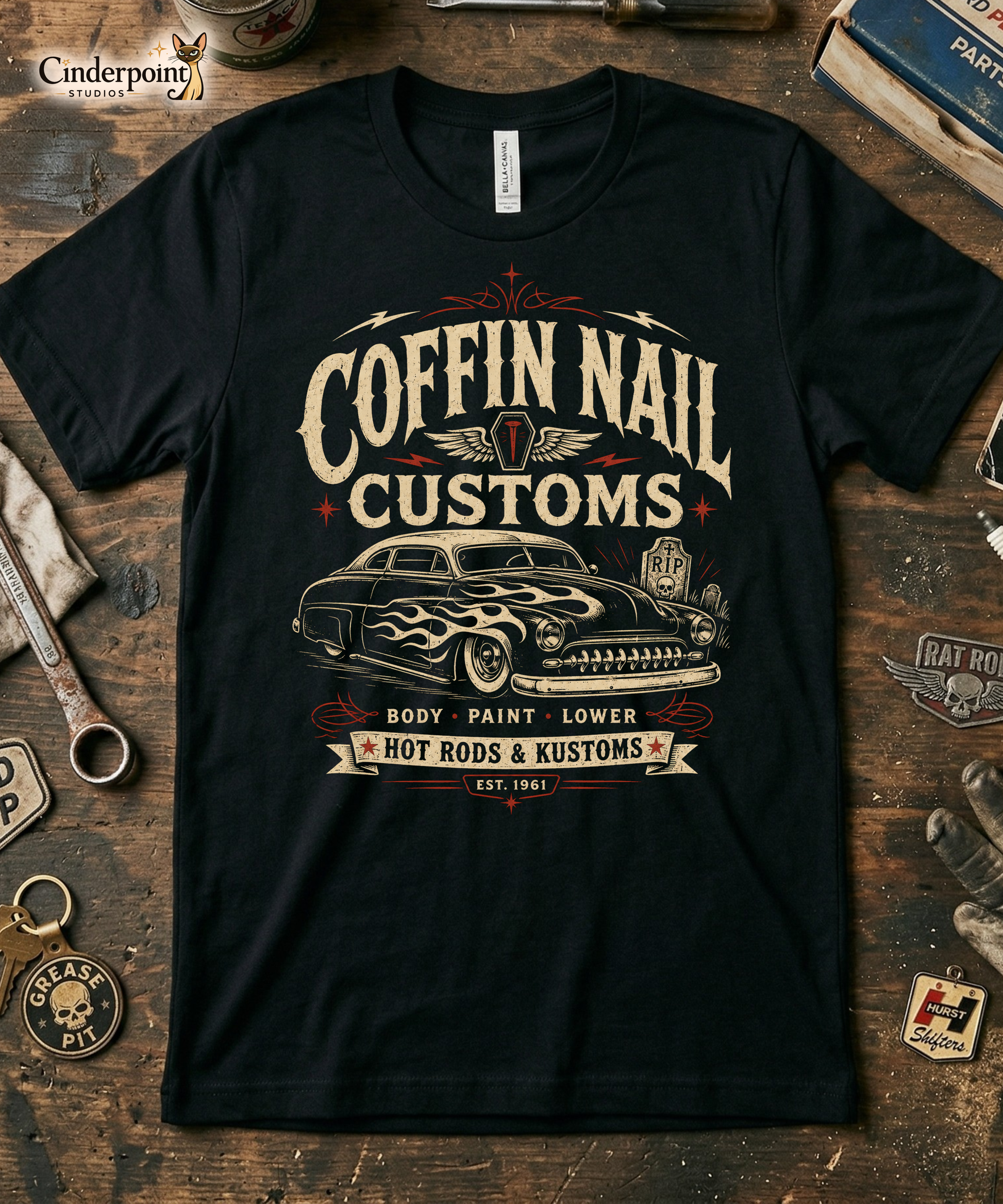 Black graphic tee featuring original Cinderpoint Studios artwork for Coffin Nail Customs, a psychobilly hot rod design with bold distressed lettering, a chopped custom lead sled, flame graphics, winged coffin nail emblem, lightning bolts, cemetery details, and Hot Rods & Kustoms text.
