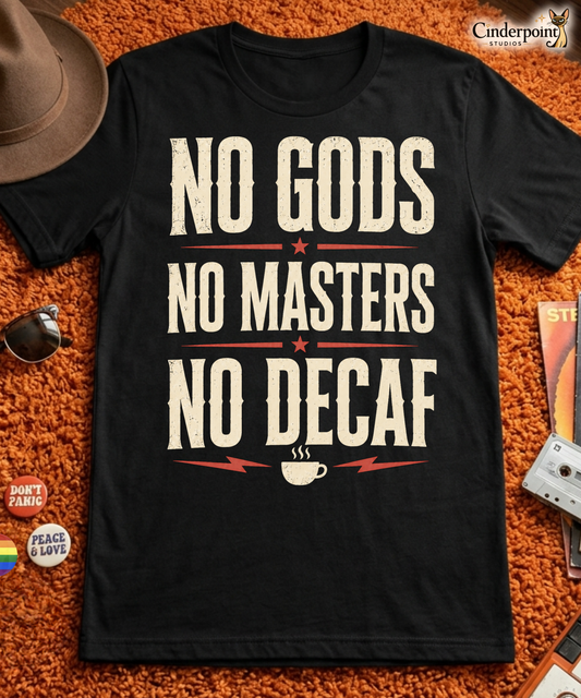 Black graphic tee featuring original Cinderpoint Studios artwork for No Gods No Masters No Decaf, a bold retro text design with cream lettering, red accent stars, lightning bolts, and a small coffee cup graphic.
