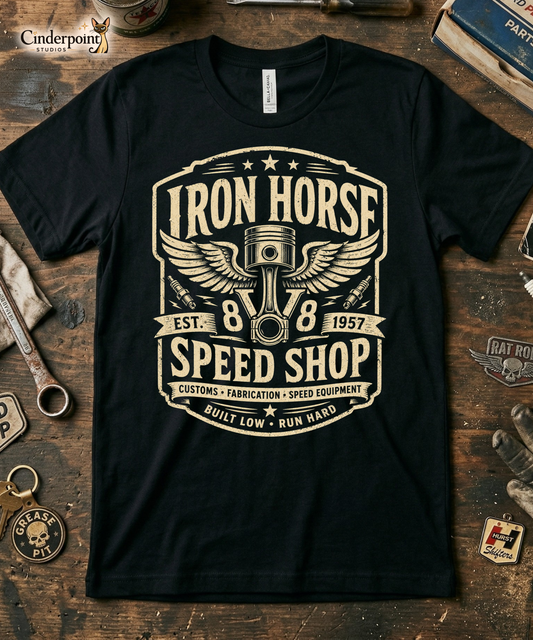 Black graphic tee featuring original Cinderpoint Studios artwork for Iron Horse Speed Shop, a one-color retro garage badge design with winged piston artwork, spark plugs, stars, banner details, V8 text, and Built Low Run Hard lettering.