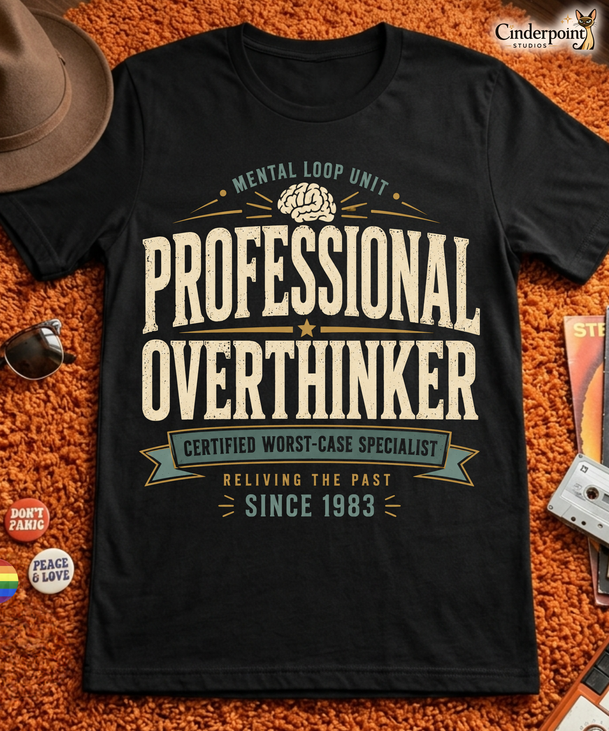 Black graphic tee featuring original Cinderpoint Studios artwork for Professional Overthinker, a retro badge-style design with bold vintage lettering, a brain graphic, and text including Mental Loop Unit, Certified Worst-Case Specialist, and Reliving the Past Since 1983.