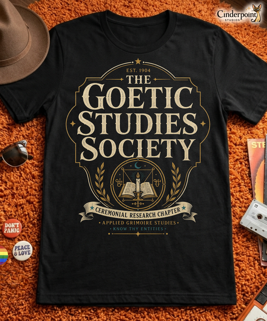 The Goetic Studies Society t-shirt design with vintage typography, candle and open book emblem, ceremonial research chapter banner, and applied grimoire studies text