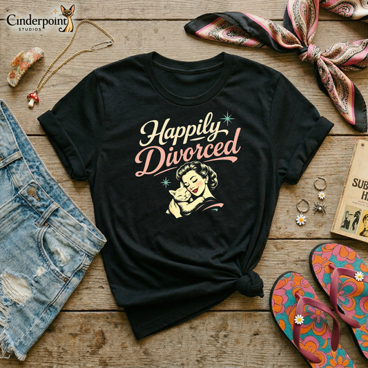 Black retro graphic t-shirt featuring the phrase Happily Divorced in cream and pink script above a vintage-inspired woman cuddling her cat with small aqua atomic starbursts.