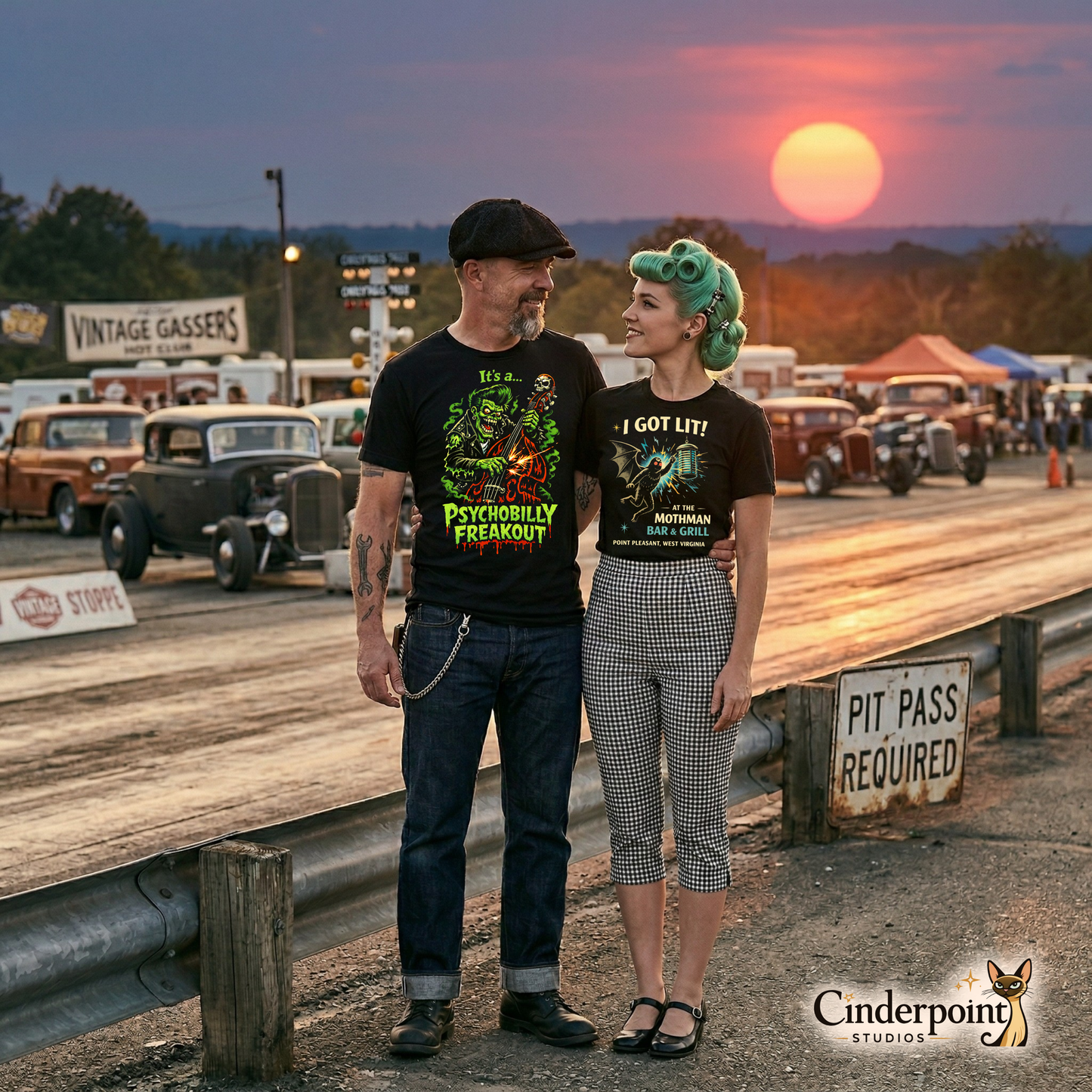 A rockabilly couple at a drag strip at sunset. The woman is wearing the Cinderpoint exclusive "Mothman Bar & Grill" tee. The man is wearing A black t-shirt featuring a vibrant neon green and orange "Psychobilly Freakout" graphic of a zombie playing an upright bass with sparks flying off the strings.