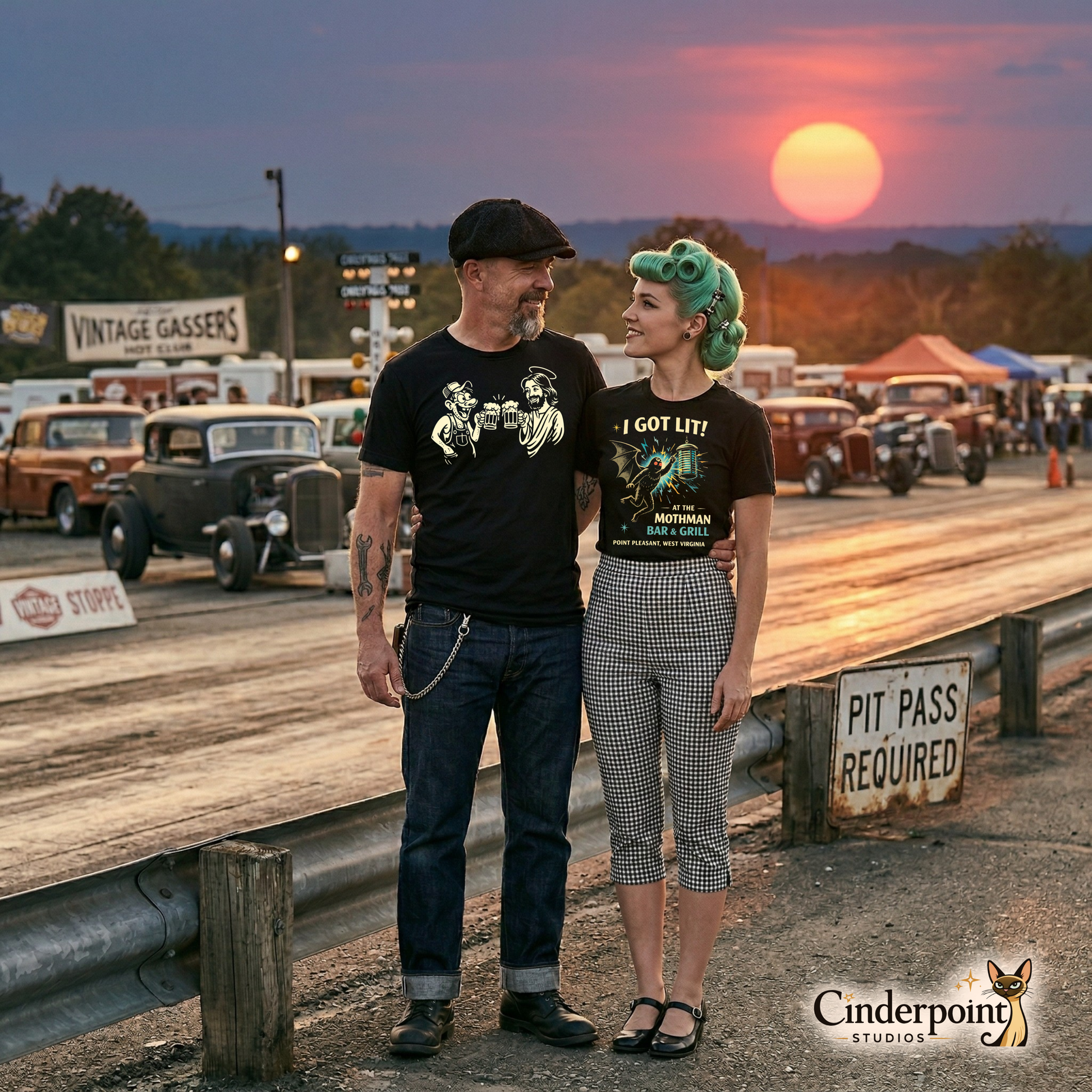 A rockabilly couple standing at a drag strip during sunset; the man wears the "Drinking With Jesus" tee while the woman stands next to him in her favorite subversive gear.