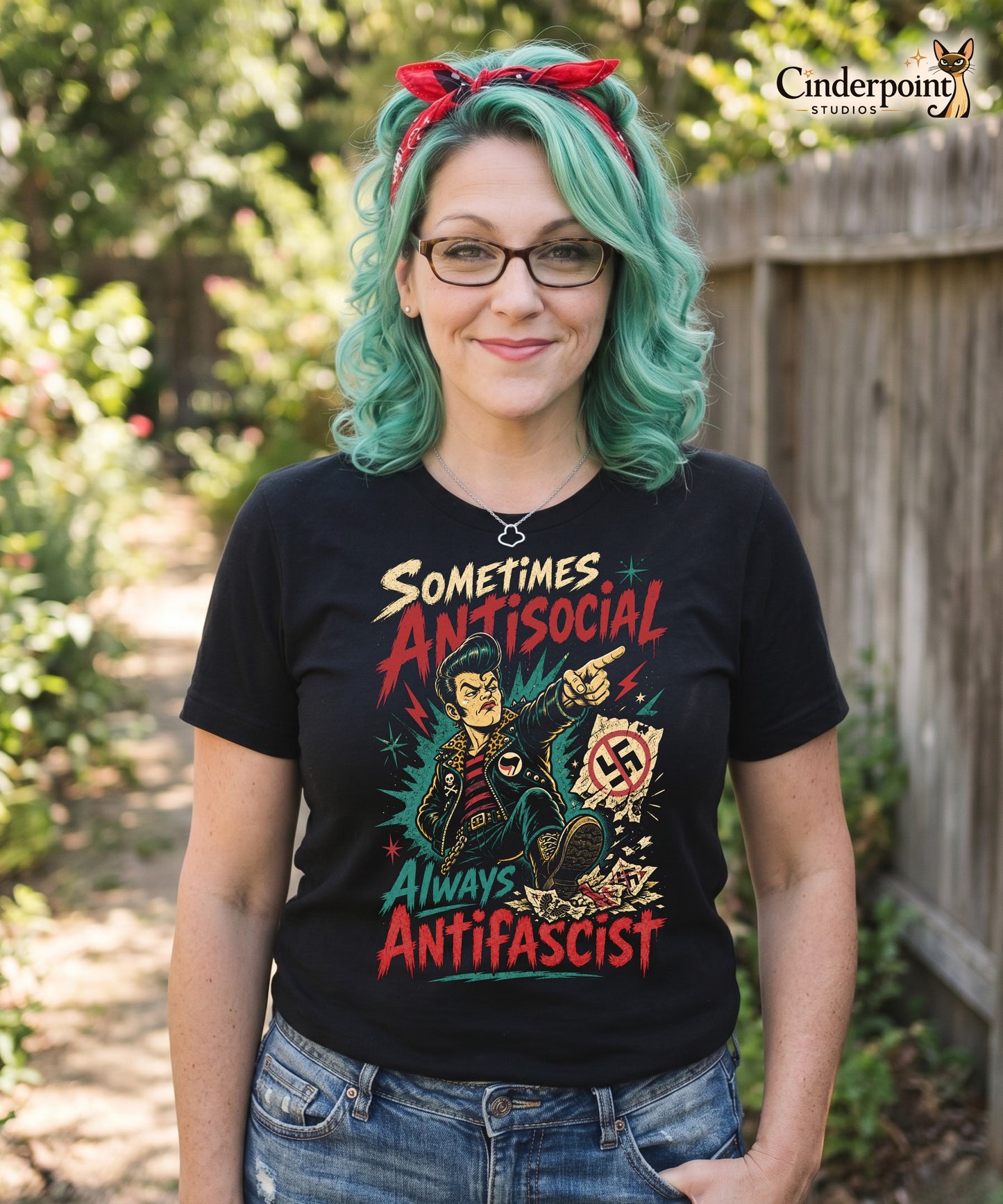 A gritty, lowbrow illustration on a black t-shirt of a pompadoured greaser in a leopard-print lined leather jacket, kicking over hate symbols. Text reads 'Sometimes Antisocial Always Antifascist' in a distressed punk-style font.