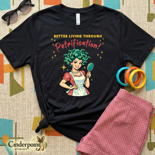 Better Living Through Petrification unisex tee — vintage 1950s retro Medusa housewife with styled snake hair holding a hand mirror and smiling confidently in pearls and apron, gold and red typography on black Bella Canvas 3001 by Cinderpoint Studios