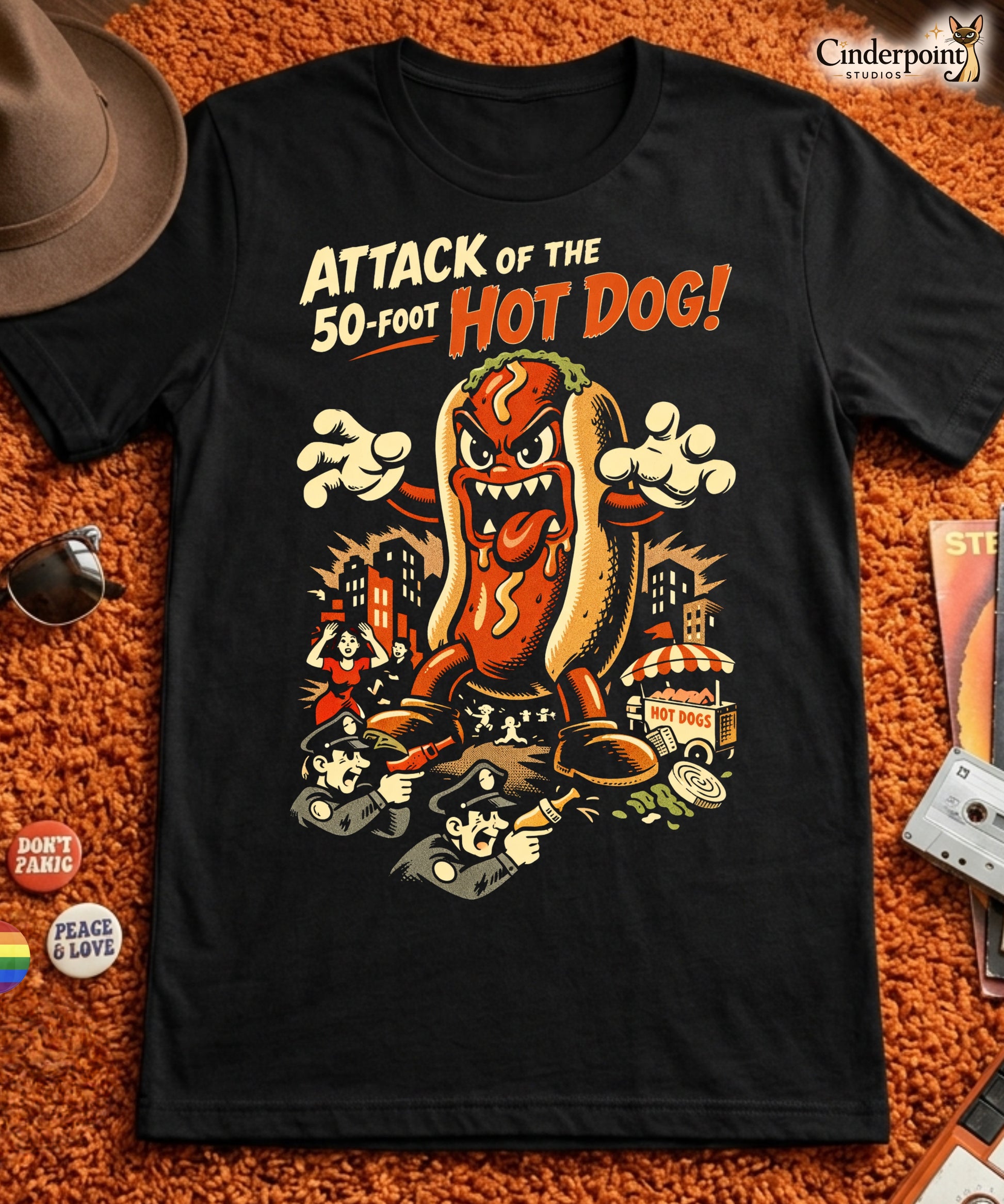 A retro B-movie style graphic t-shirt featuring a giant 50-foot hot dog attacking a vintage city skyline, with campy horror-themed cinematic lettering.