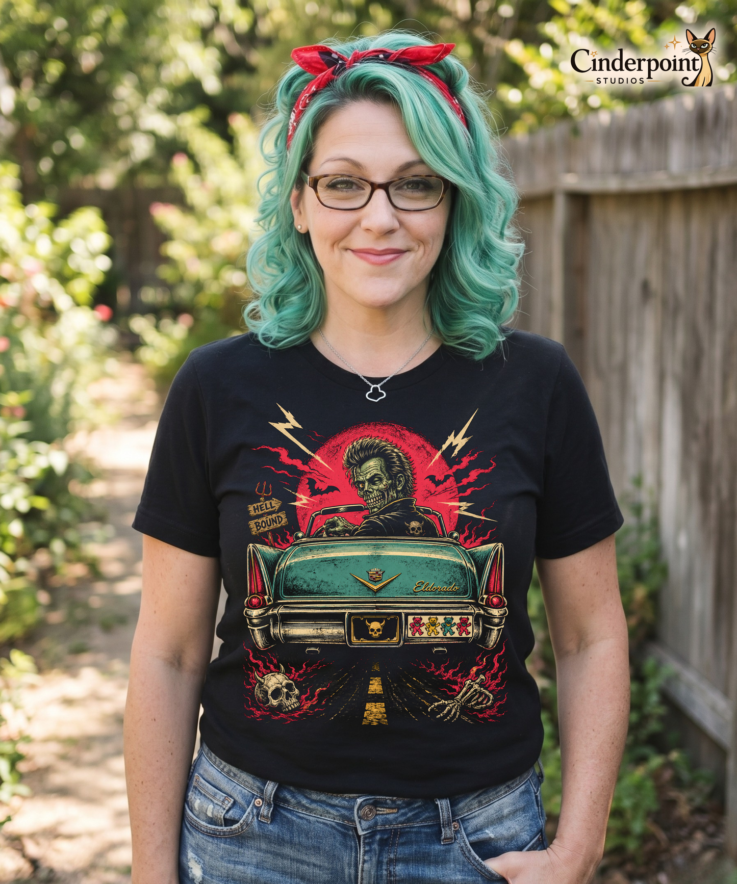 Auntie Mel is wearing  A retro graphic on a black t-shirt featuring a horror punk zombie driver and the rear end of a vintage Cadillac with grateful dead bumper sticker