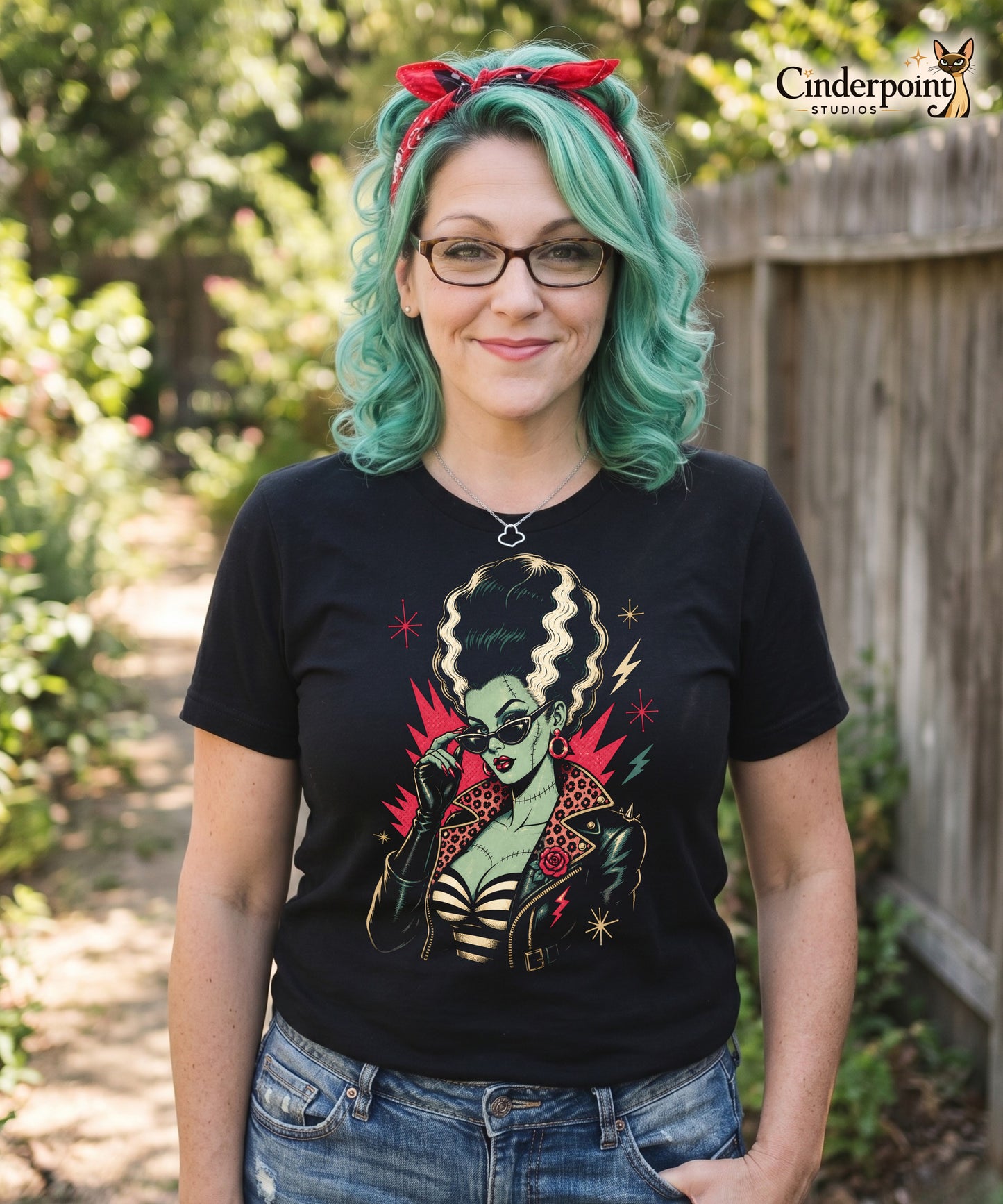 Artistic illustration of a green-skinned monster bride with high-volume black and white hair, cat-eye sunglasses, and a leopard-print lined leather jacket on a black t-shirt.