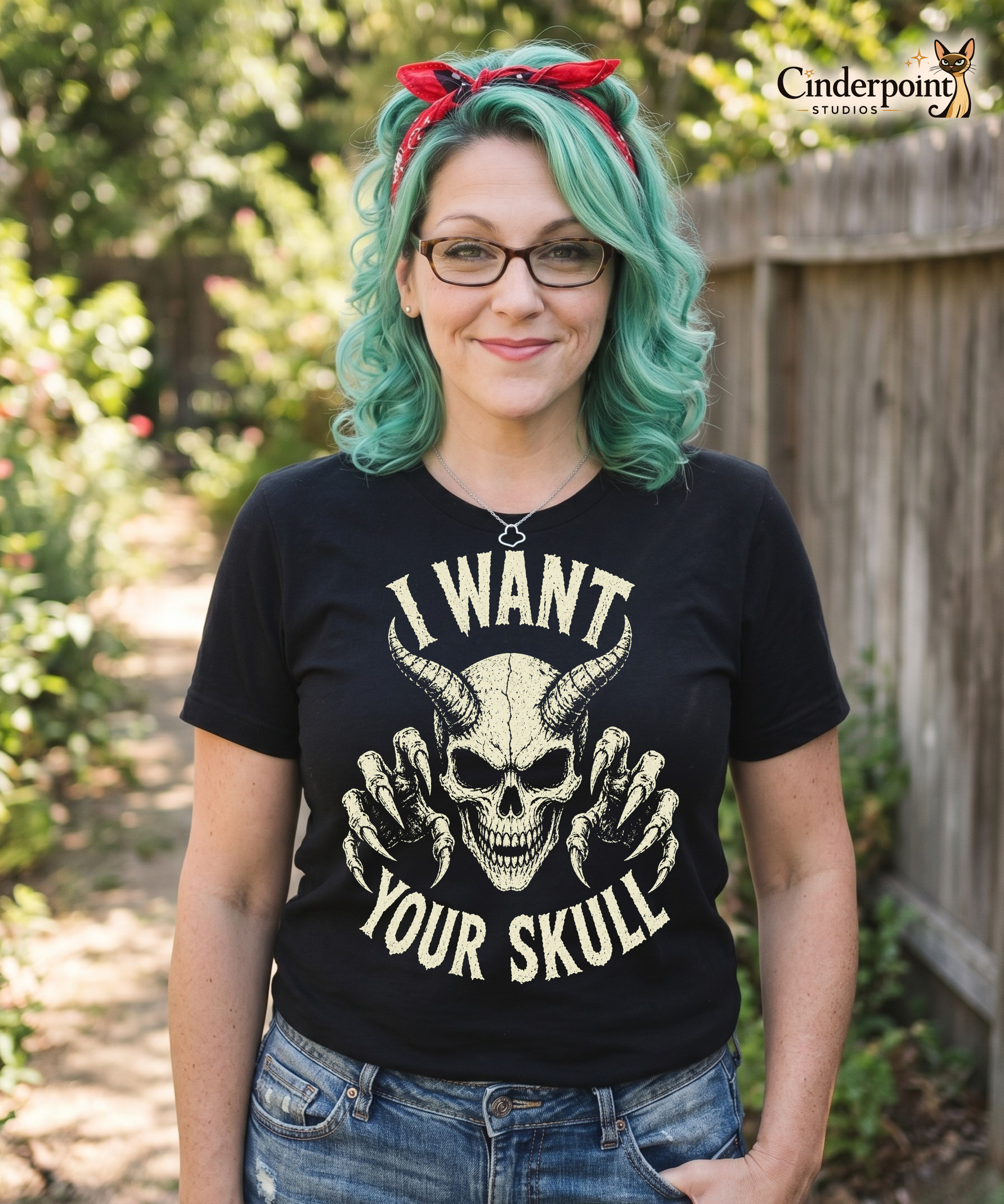 Auntie Mel wearing A retro-style graphic on a black t-shirt featuring a detailed horned demon skull with sharp claws and "I WANT YOUR SKULL" in distressed punk-rock lettering.