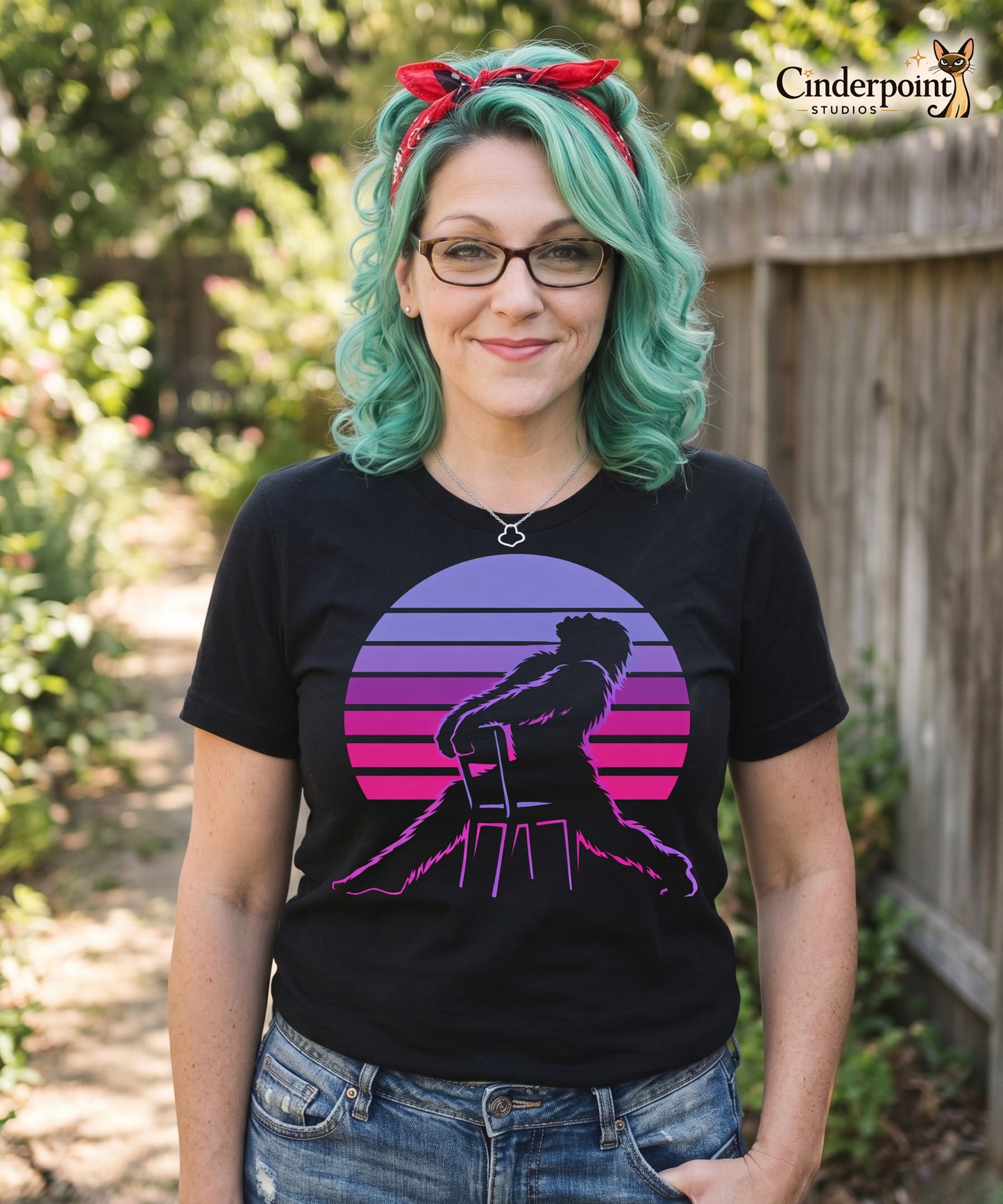 A retro graphic t-shirt featuring the cryptid Bigfoot in the iconic Flashdance chair-pose silhouette against a vibrant 1980s-style sunset.