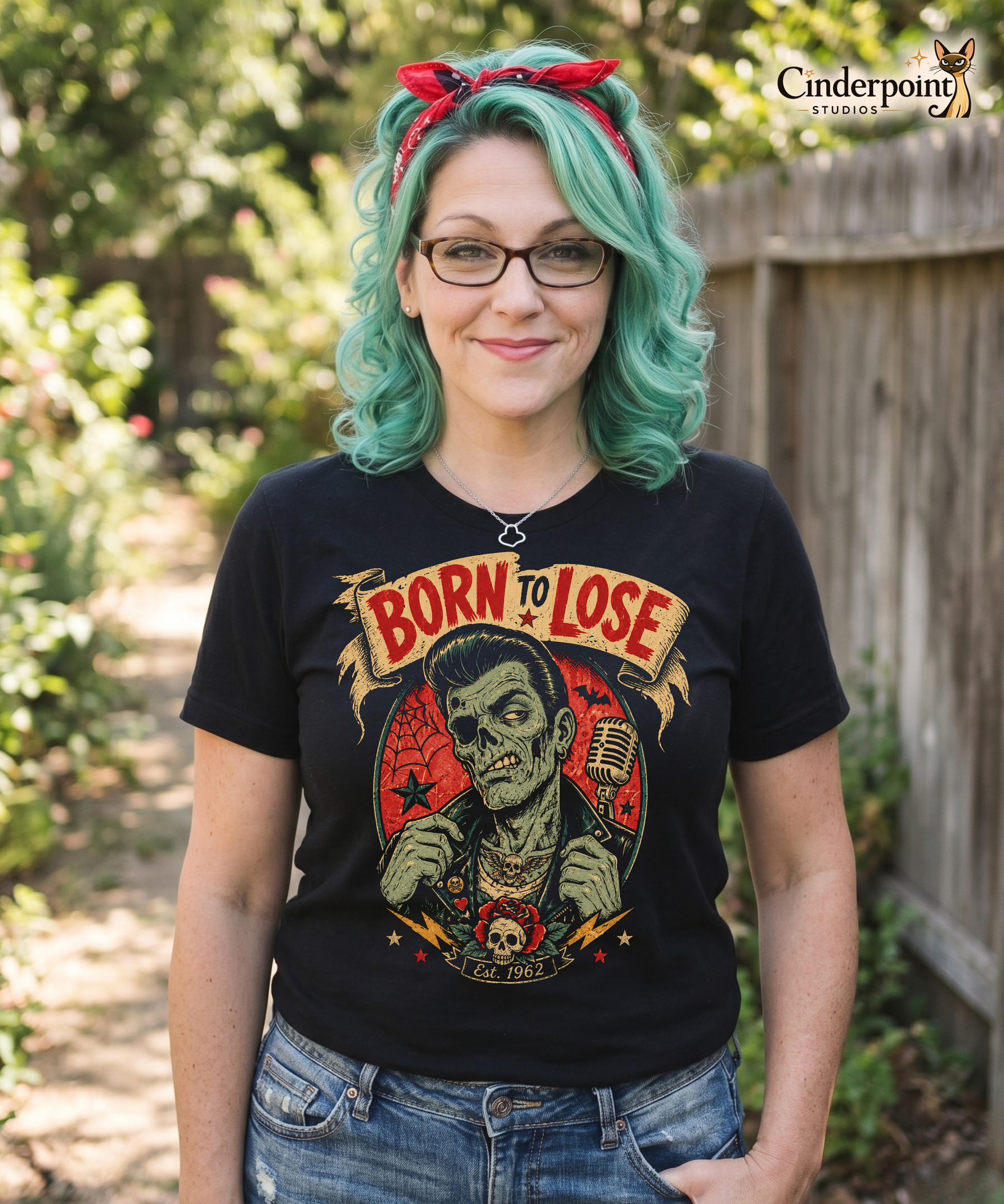 Auntie Mel wearing A vintage tattoo flash-style graphic on a black t-shirt featuring a green-skinned zombie monster with a banner that says "Born to Lose"