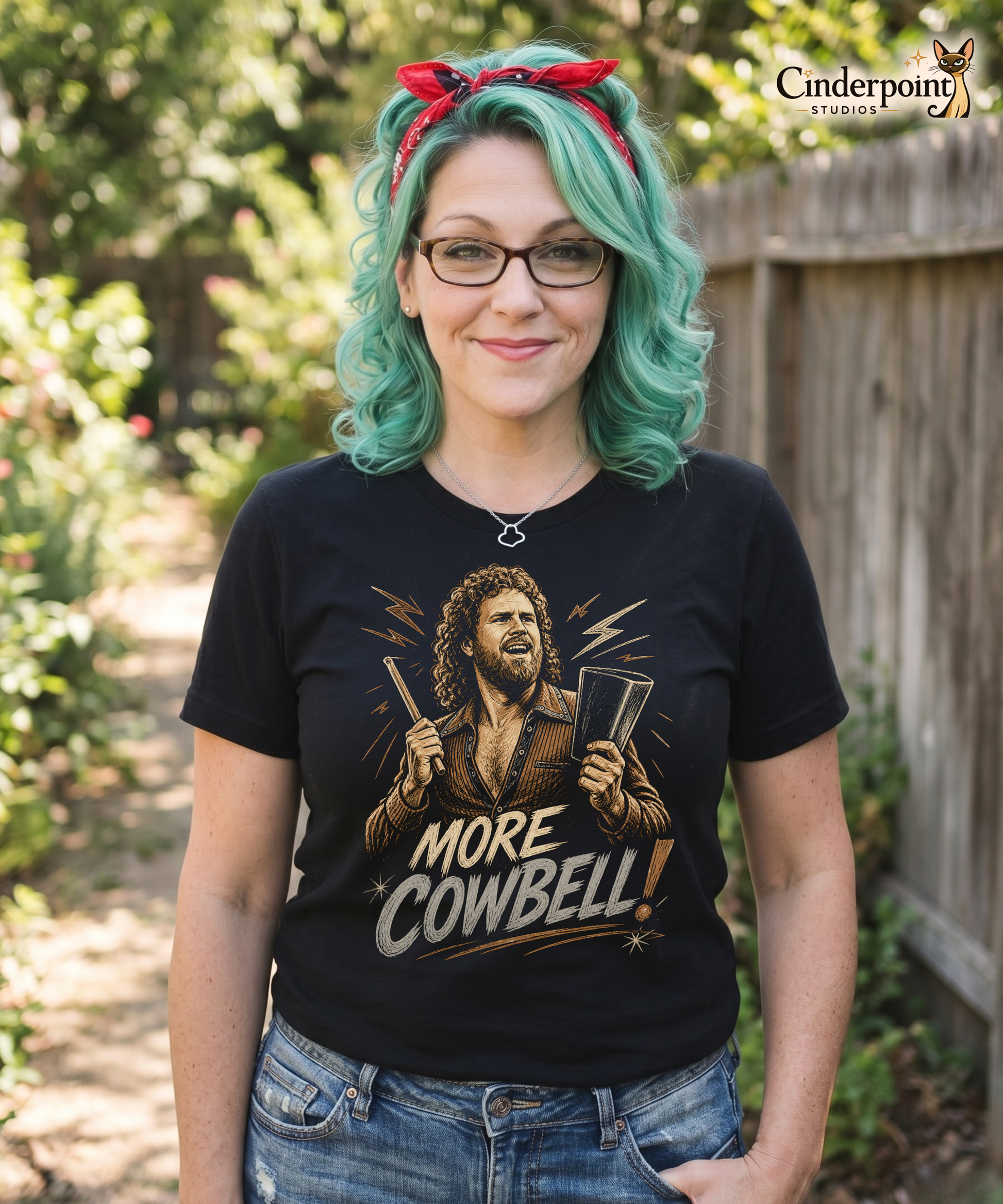 A gritty, woodcut-style illustration on a black t-shirt featuring a bearded man with curly hair and an open-collared 70s shirt holding a cowbell and drumstick, with the text 'MORE COWBELL!' in a distressed font.