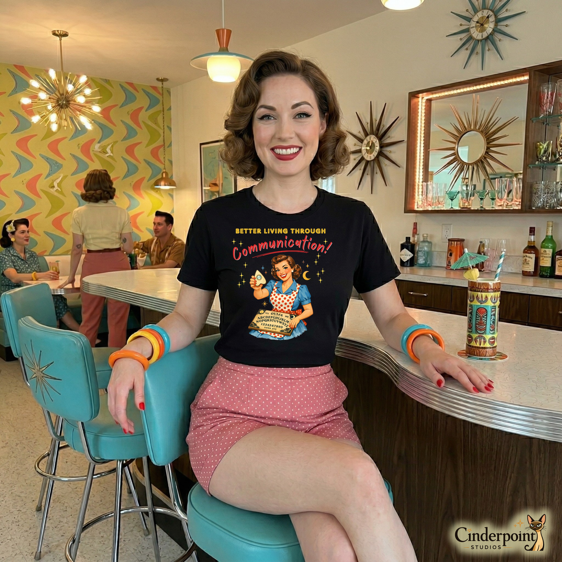 Woman sitting at a retro-style diner counter wearing a vintage-themed t-shirt.