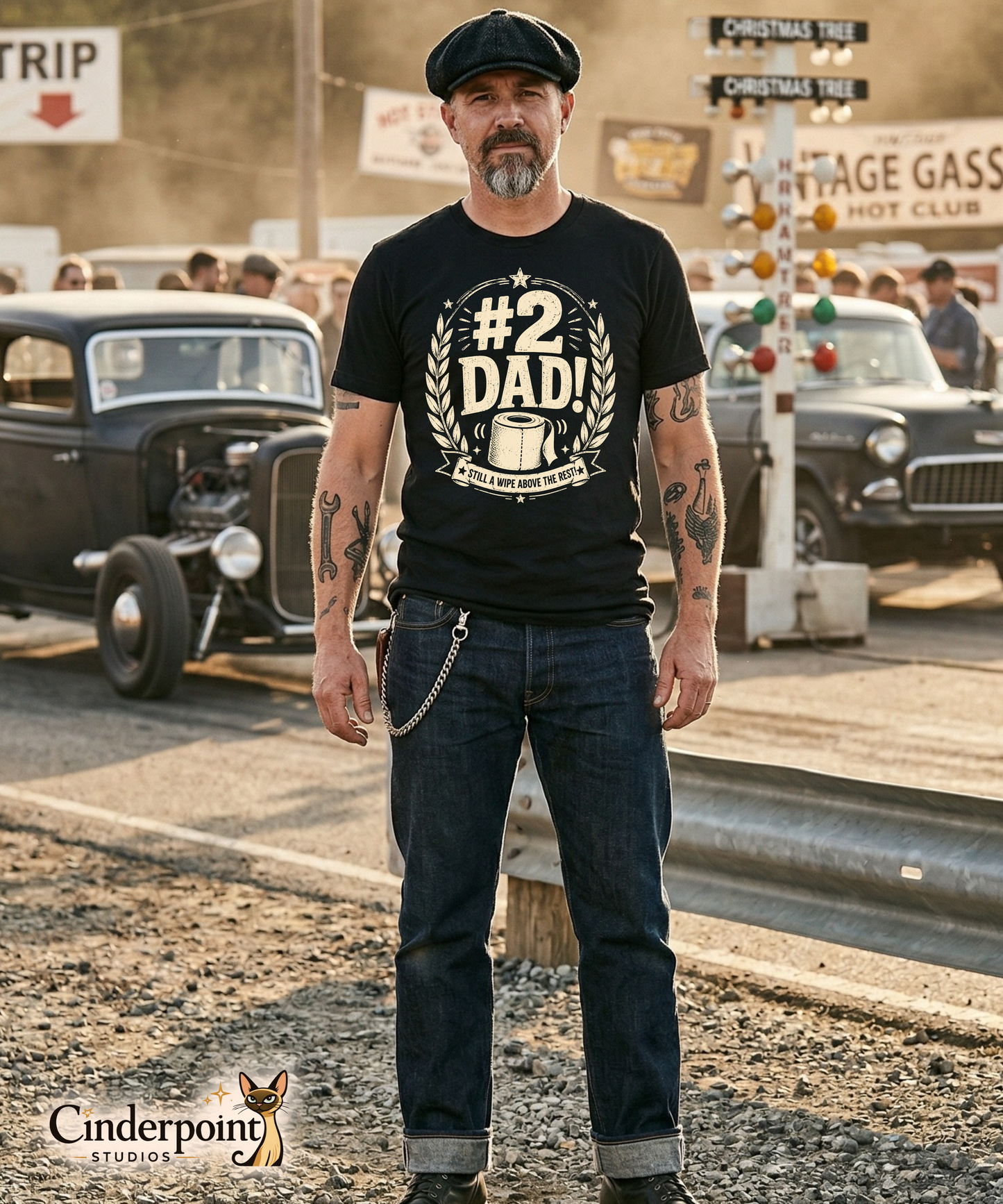 Man wearing a black graphic tee featuring original Cinderpoint Studios artwork for #2 Dad, a one-color funny dad design with bold retro lettering, laurel accents, stars, a toilet paper roll illustration, and the phrase Still a Wipe Above the Rest!