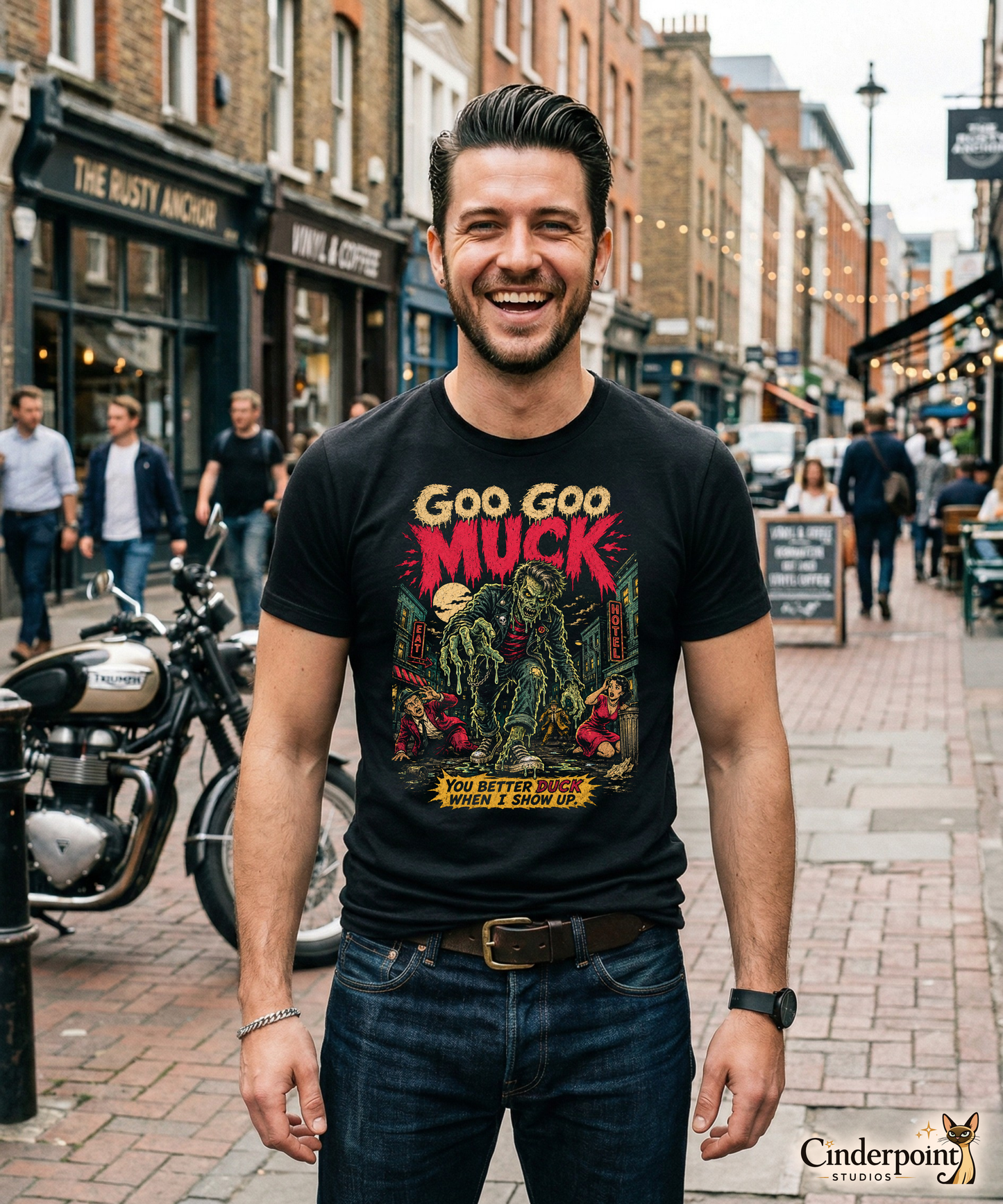 A retro-style graphic on a black t-shirt featuring a teenage monster with a pompadour, wearing a red and black striped shirt and a black leather jacket, with "GOO GOO MUCK" in distressed lettering.