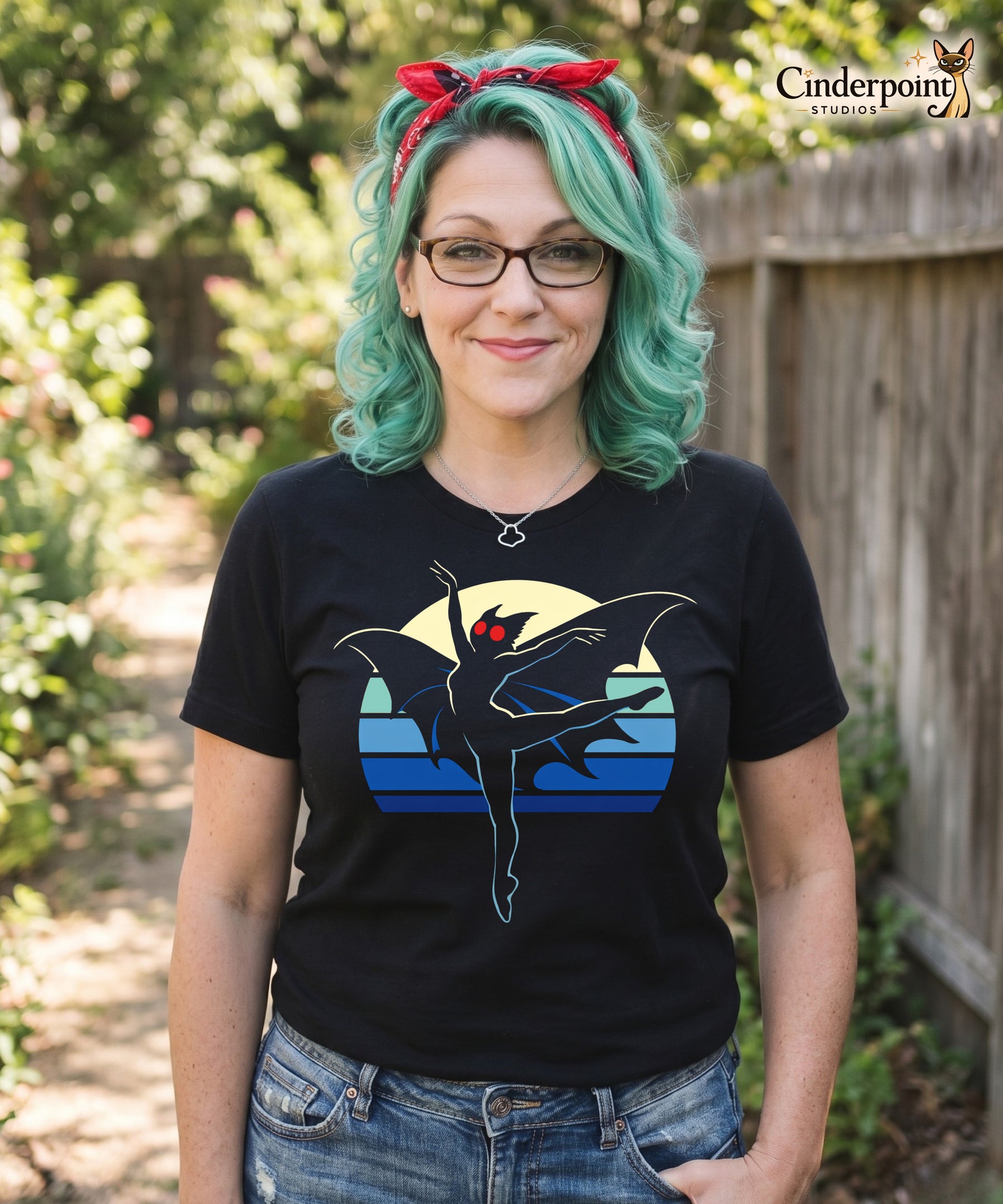 A retro-style graphic t-shirt featuring the winged cryptid Mothman in a ballet dance pose wearing a tutu, set against a vibrant neon 80s sunburst background.