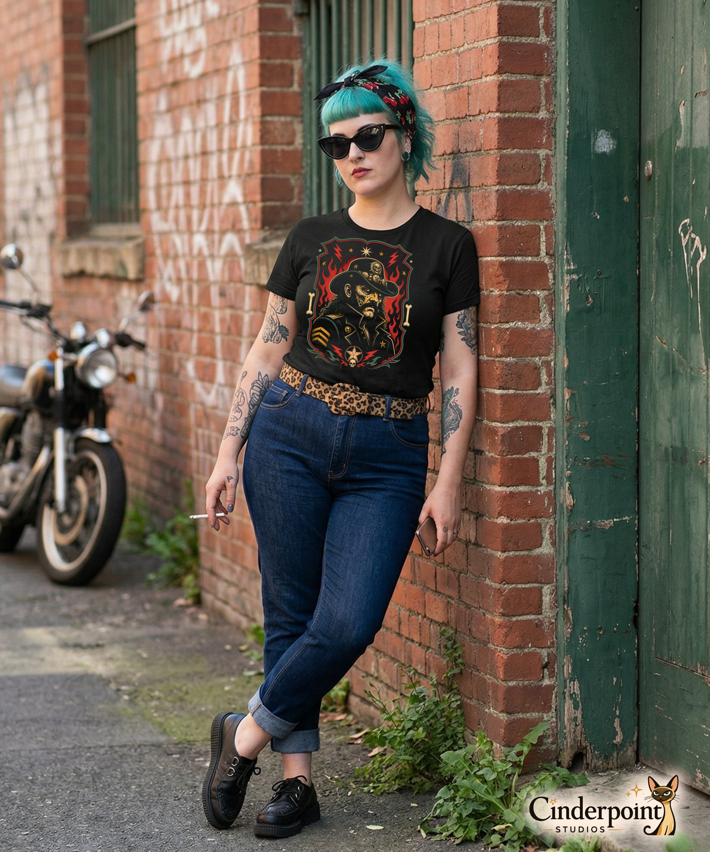 Graphic t-shirt design featuring a lowbrow undead version of Lemmy in a military-style hat with skulls and stars, framed by red flames and lightning bolts on a black background.