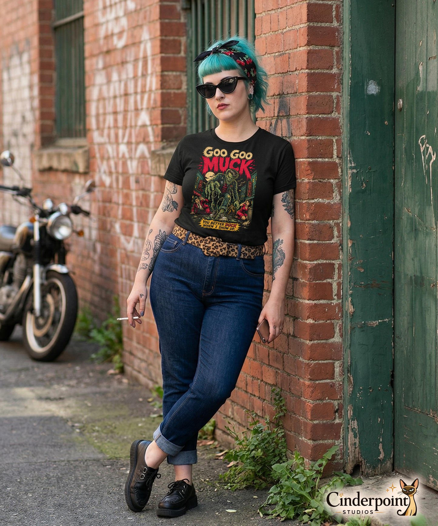 A retro-style graphic on a black t-shirt featuring a teenage monster with a pompadour, wearing a red and black striped shirt and a black leather jacket, with "GOO GOO MUCK" in distressed lettering.