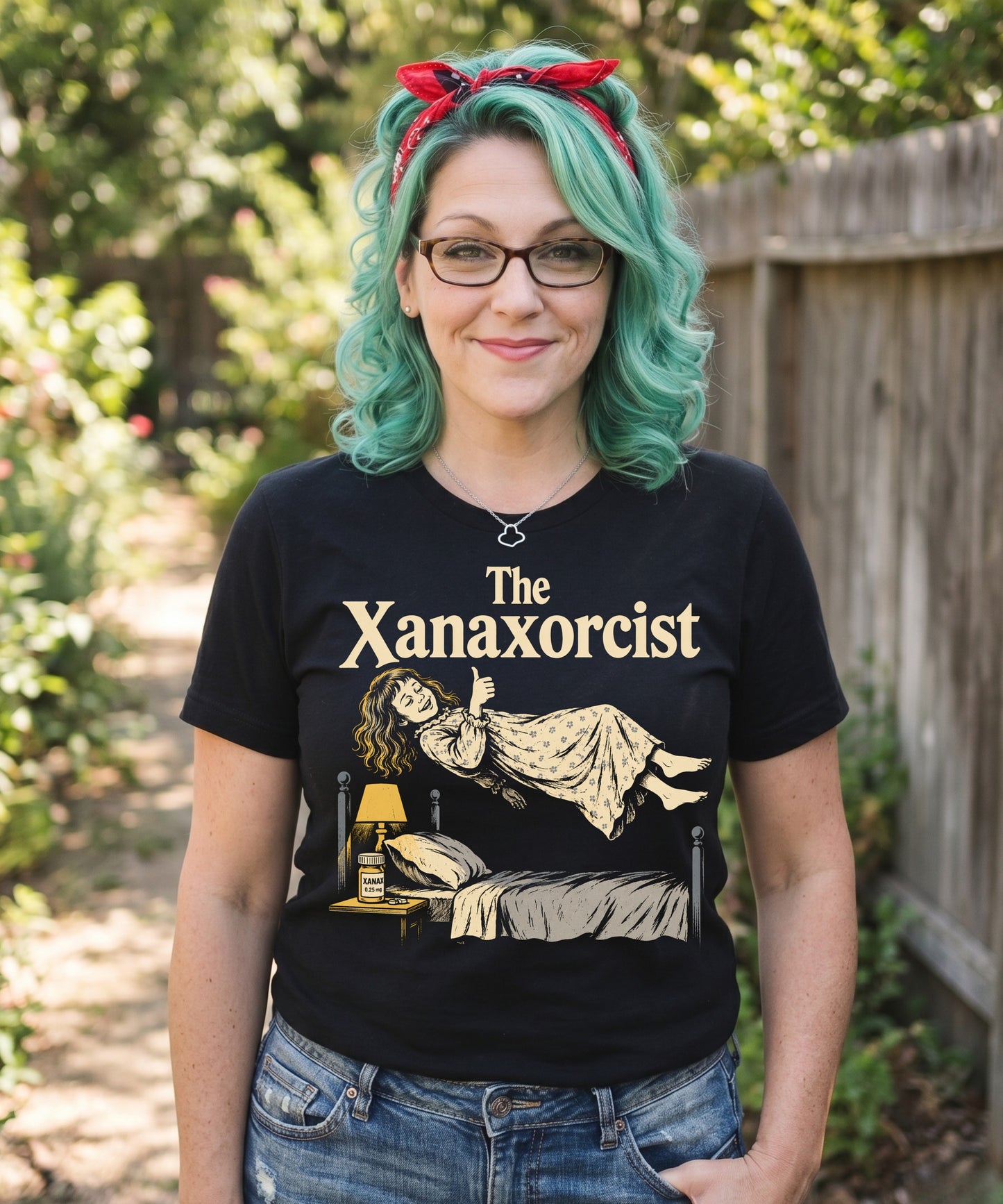 A retro horror-style graphic t-shirt featuring "The Xanaxorcist" in classic cinematic lettering with a stylized, eerie parody of the iconic exorcism scene.