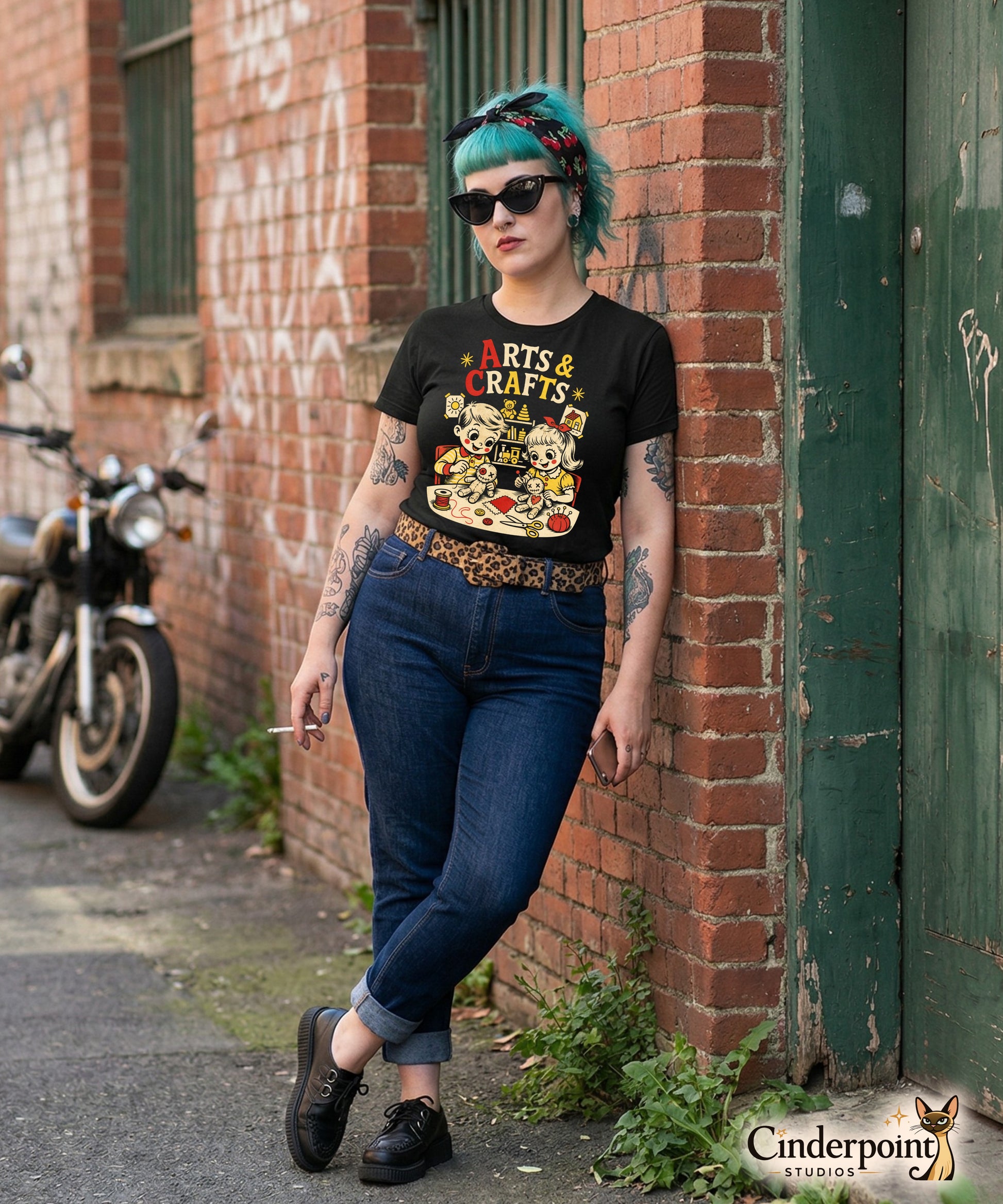 A retro-style graphic t-shirt featuring a creepy-cute voodoo doll with "Arts & Crafts" in stylized, vintage-inspired lettering, perfect for dark humor and goth fans.