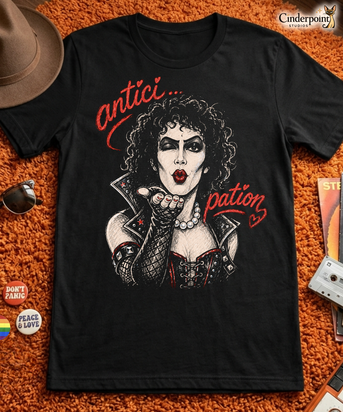 A gritty, high-contrast artistic portrait of Frank N. Furter on a black t-shirt, featuring his iconic curls and makeup with the word "ANTICIPATION" in distressed lipstick lettering.