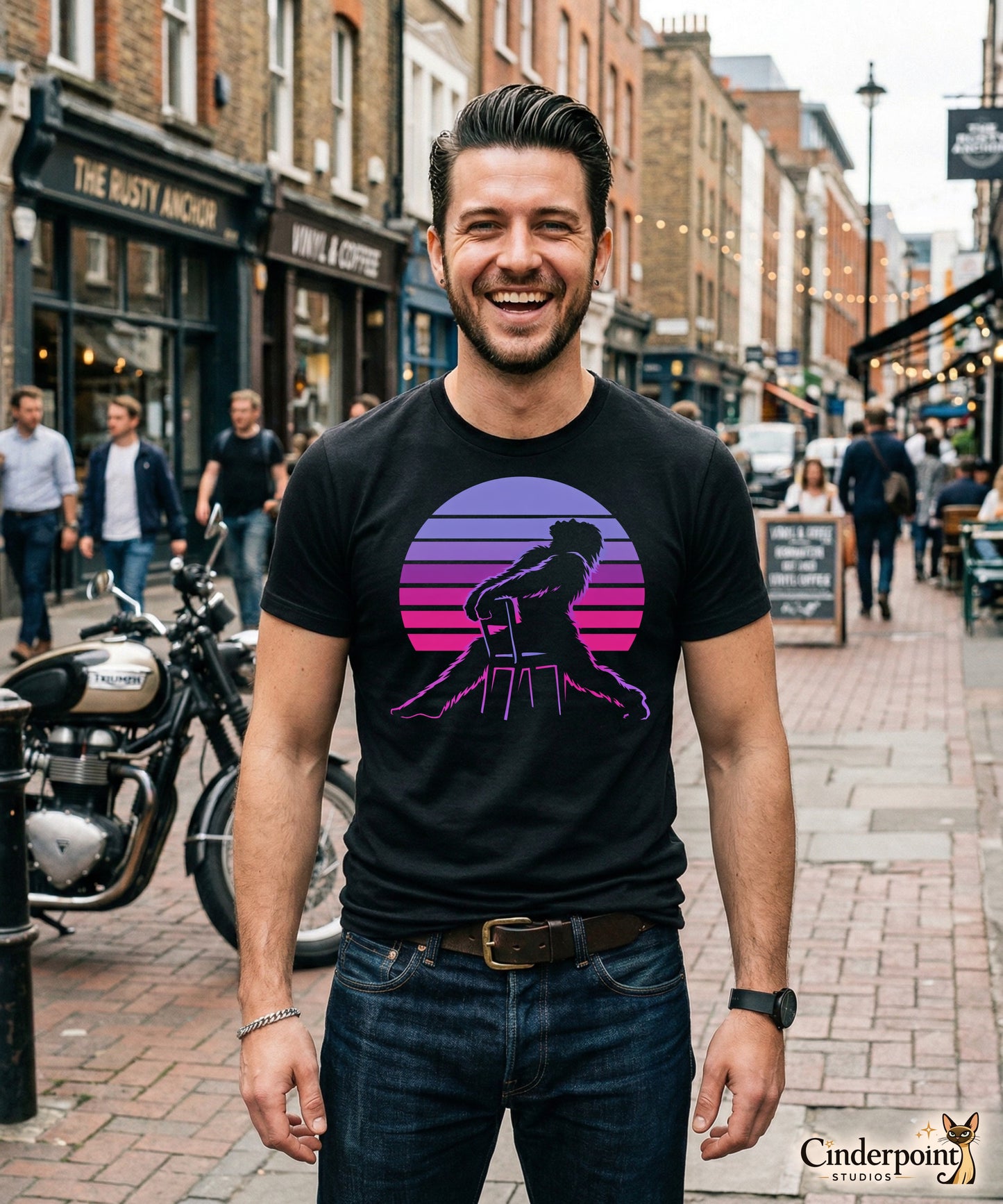 A retro graphic t-shirt featuring the cryptid Bigfoot in the iconic Flashdance chair-pose silhouette against a vibrant 1980s-style sunset.