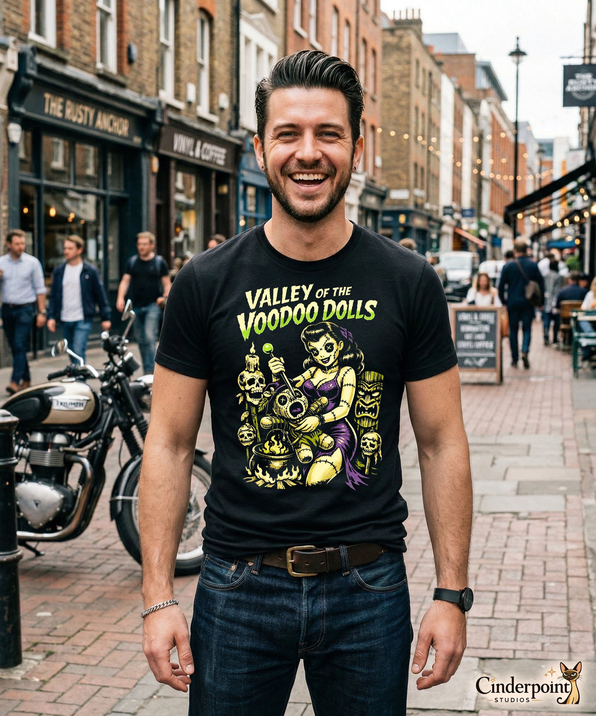 A retro-style graphic on a black t-shirt featuring a stylized pinup girl voodoo doll turning the tables on a medicine man in a vibrant, gritty Tiki-horror aesthetic