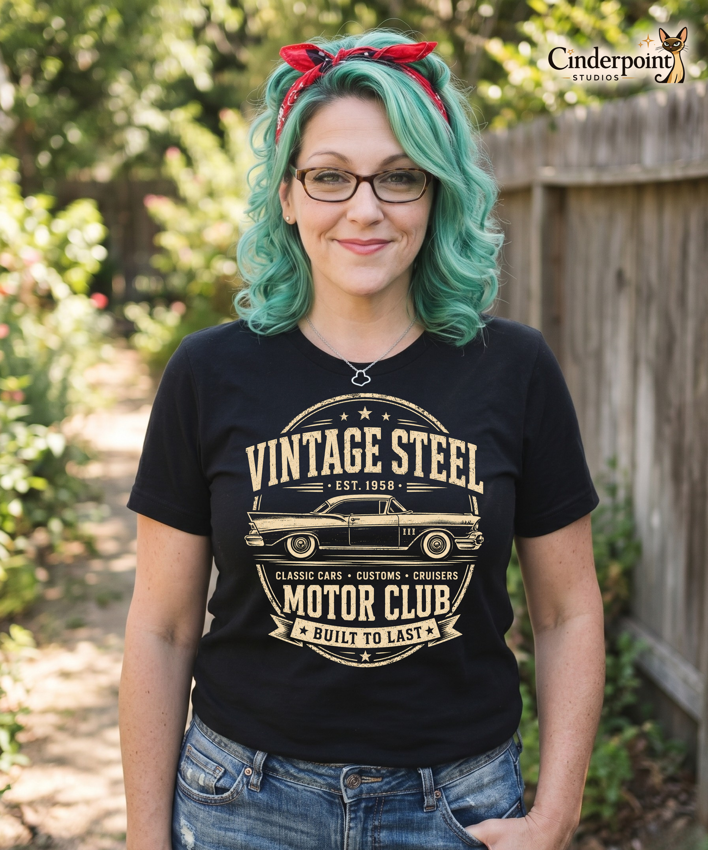 The designer, Auntie Mel, wearing a Workbench with a black graphic tee featuring original Cinderpoint Studios artwork for Vintage Steel Motor Club, a one-color classic car club design with a side-profile vintage car, bold lettering, stars, badge-style framing, Classic Cars Customs Cruisers text, and Built to Last banner.