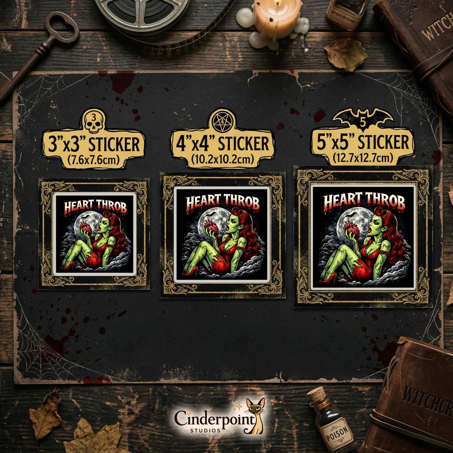 A dark wood tabletop featuring three "Heart Throb" stickers in 3-inch, 4-inch, and 5-inch sizes. Styled with a "Witchcraft" grimoire, poison bottles, a candle, and a brass skeleton key.