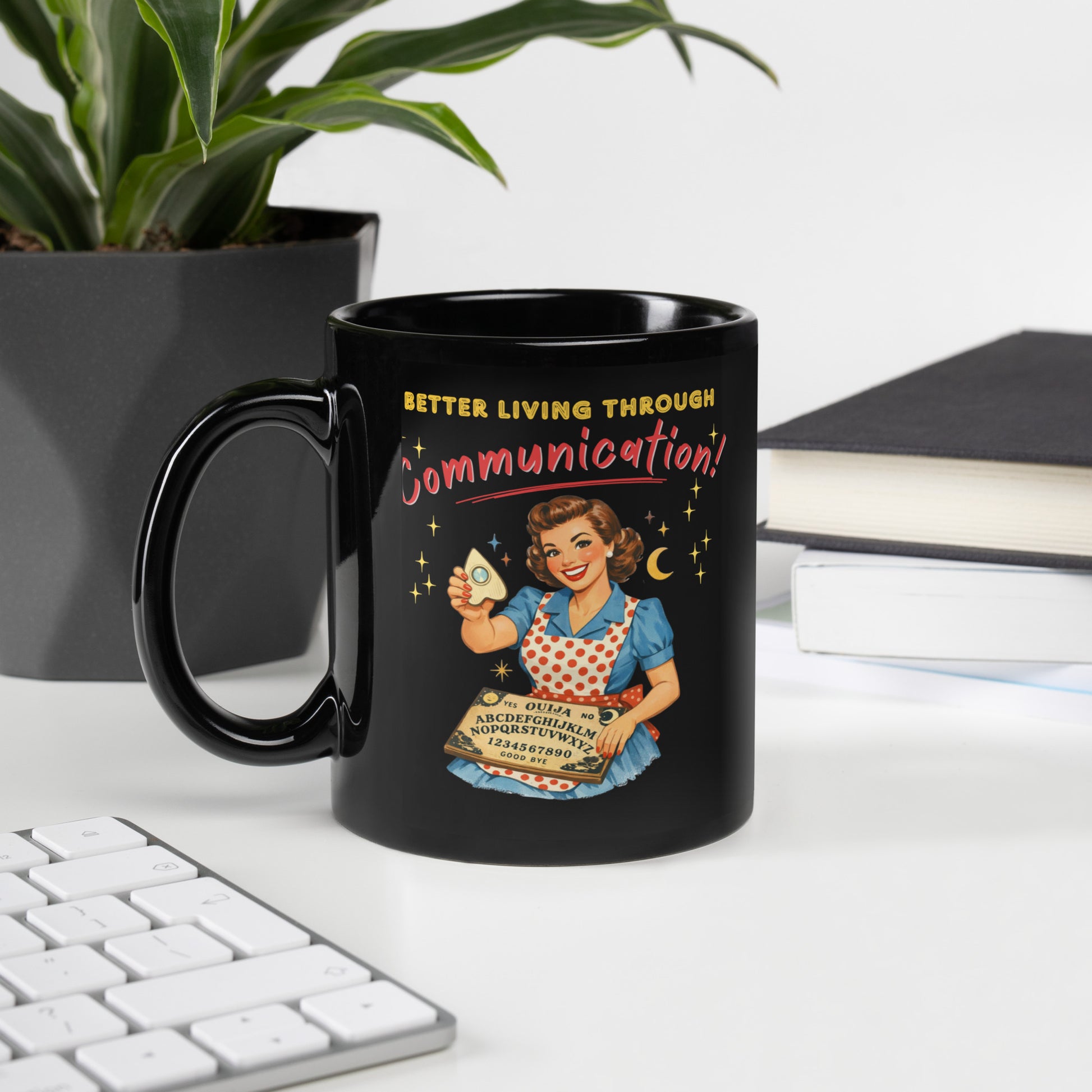 Better Living Through Communication black ceramic mug — vintage 1950s retro housewife in polka dot apron holding ouija board and planchette, printed on both sides by Cinderpoint Studios
