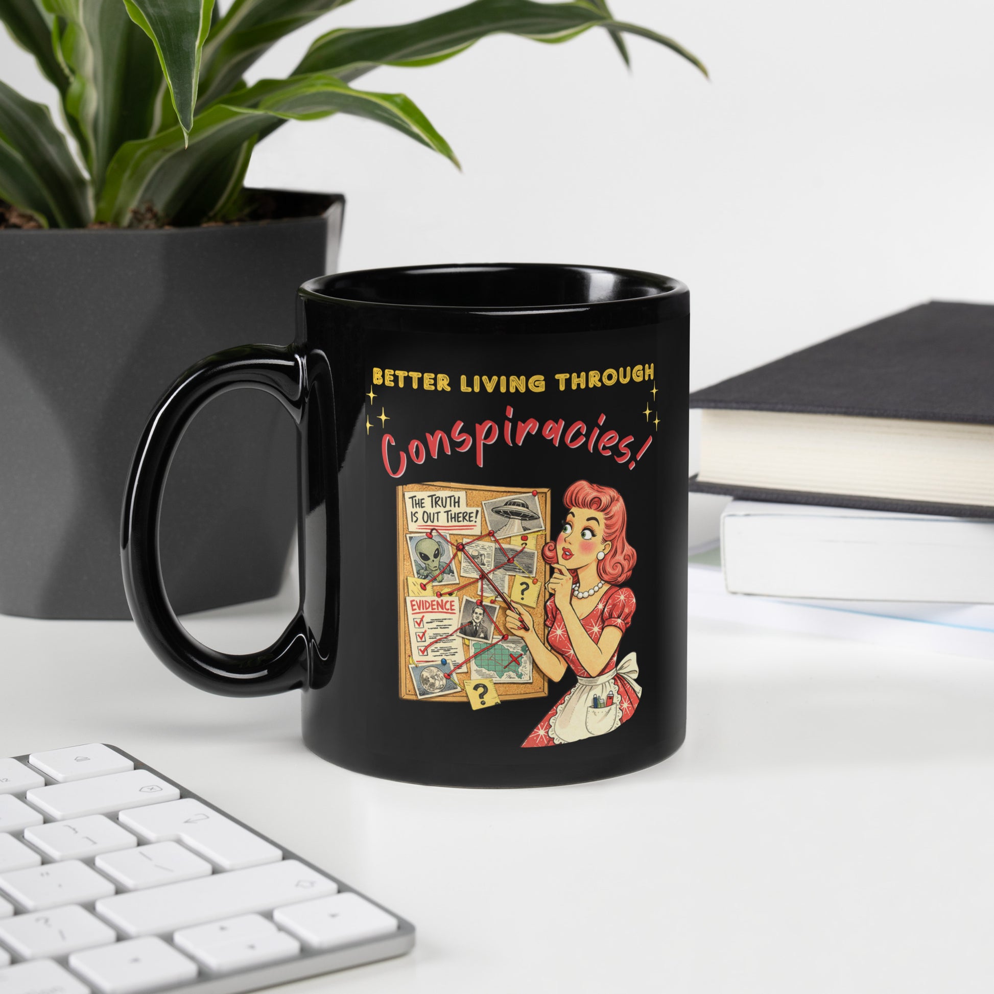 Better Living Through Conspiracies black ceramic mug — vintage 1950s retro housewife pointing at alien evidence cork board with red string and UFO photos, printed on both sides by Cinderpoint Studios