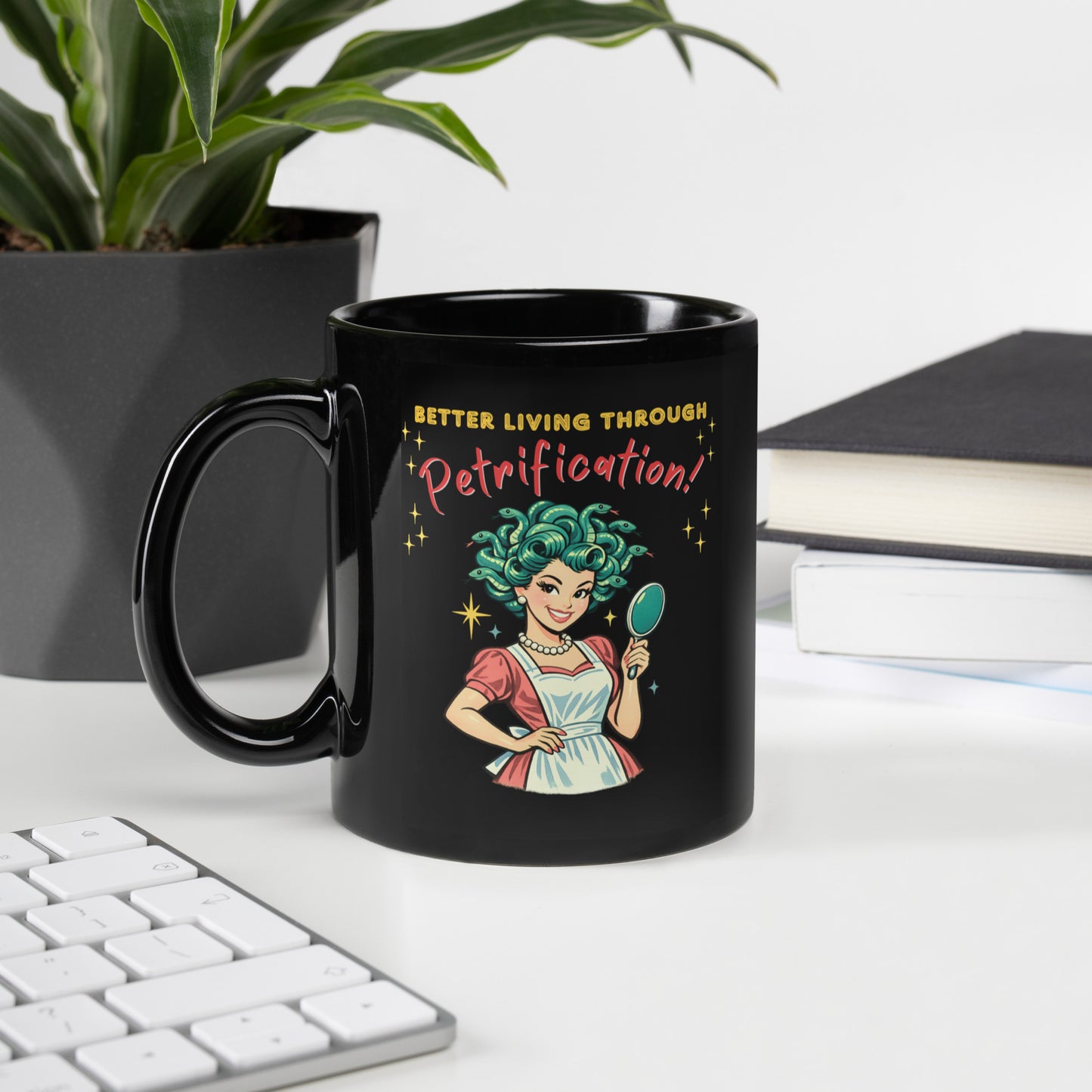 Better Living Through Petrification black ceramic mug — vintage 1950s retro Medusa housewife with styled snake hair holding a hand mirror and smiling confidently in pearls and apron, printed on both sides by Cinderpoint Studios