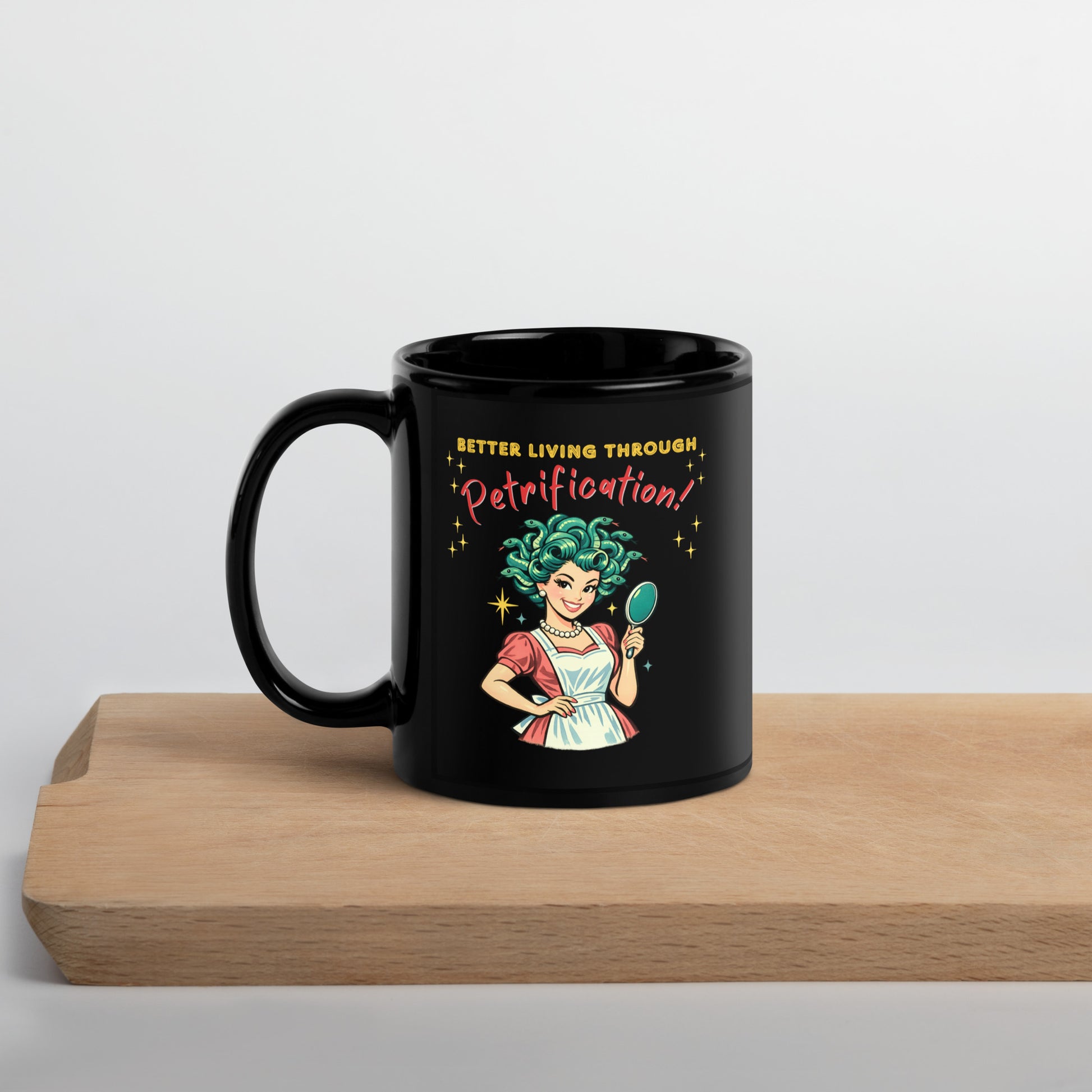 Better Living Through Petrification black ceramic mug — vintage 1950s retro Medusa housewife with styled snake hair holding a hand mirror and smiling confidently in pearls and apron, printed on both sides by Cinderpoint Studios