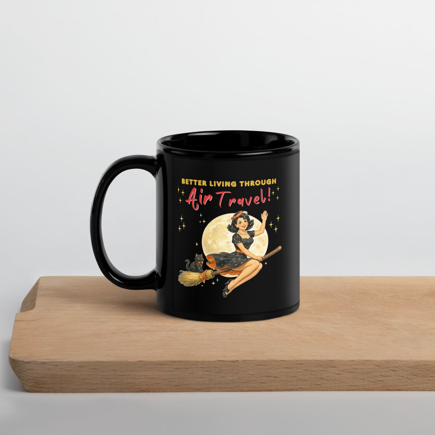 Better Living Through Air Travel black ceramic mug — vintage retro pinup witch in black polka dot dress and stewardess hat riding a broom in front of a full moon with dapper black cat familiar in orange bow tie, printed on both sides by Cinderpoint Studios