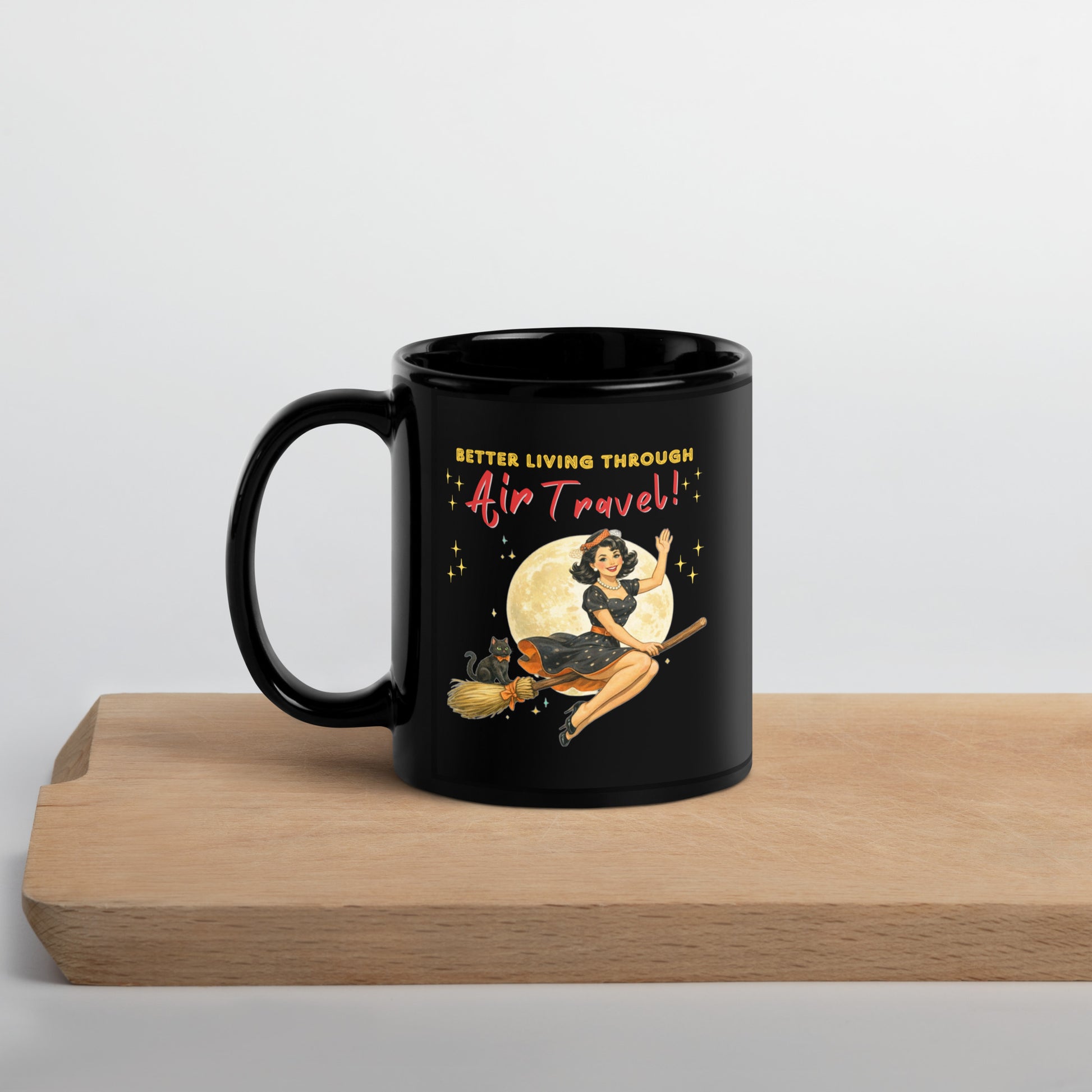 Better Living Through Air Travel black ceramic mug — vintage retro pinup witch in black polka dot dress and stewardess hat riding a broom in front of a full moon with dapper black cat familiar in orange bow tie, printed on both sides by Cinderpoint Studios