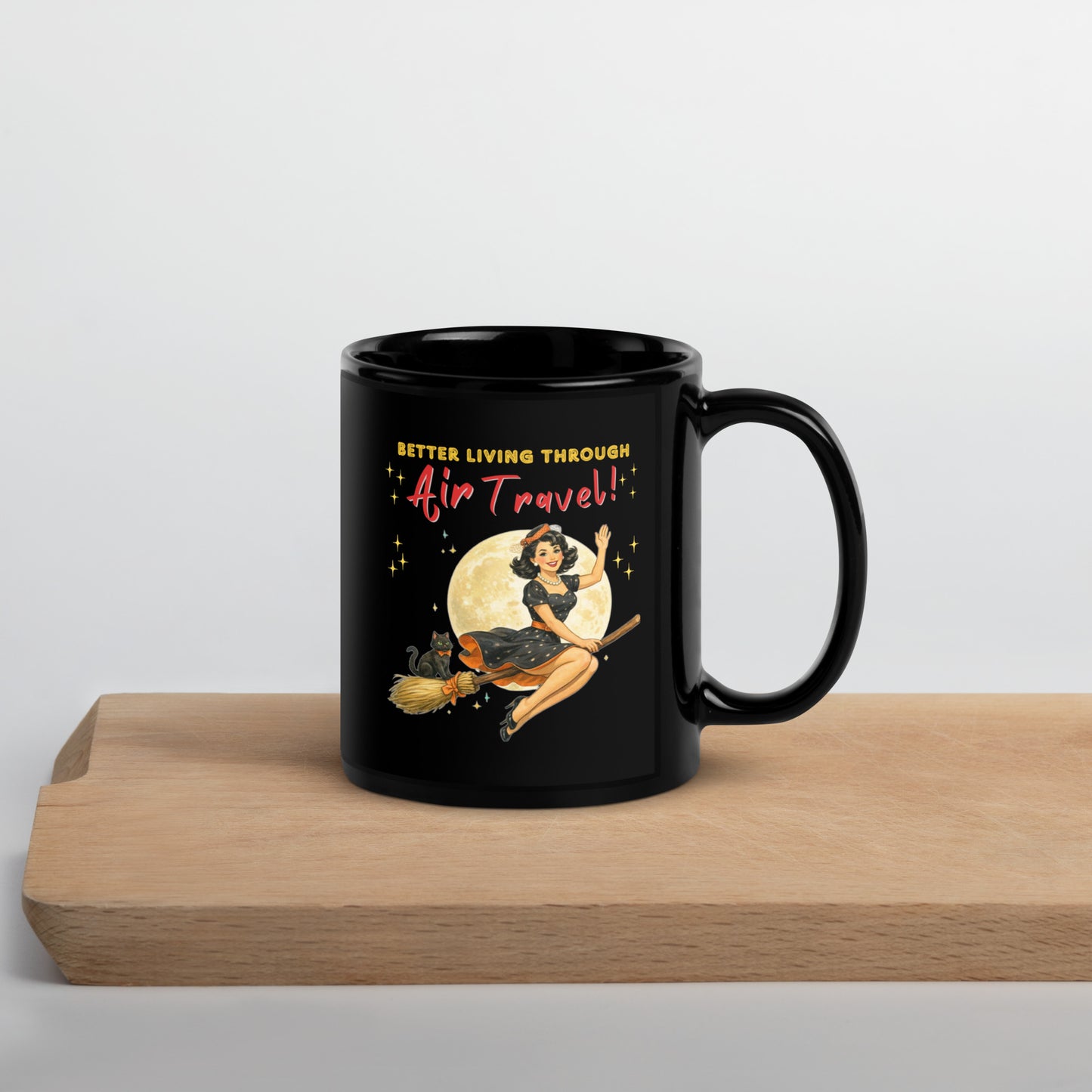 Better Living Through Air Travel black ceramic mug — vintage retro pinup witch in black polka dot dress and stewardess hat riding a broom in front of a full moon with dapper black cat familiar in orange bow tie, printed on both sides by Cinderpoint Studios