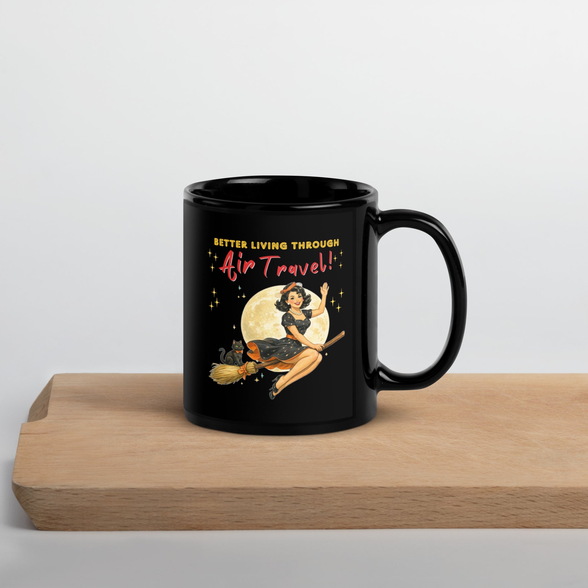 Better Living Through Air Travel black ceramic mug — vintage retro pinup witch in black polka dot dress and stewardess hat riding a broom in front of a full moon with dapper black cat familiar in orange bow tie, printed on both sides by Cinderpoint Studios