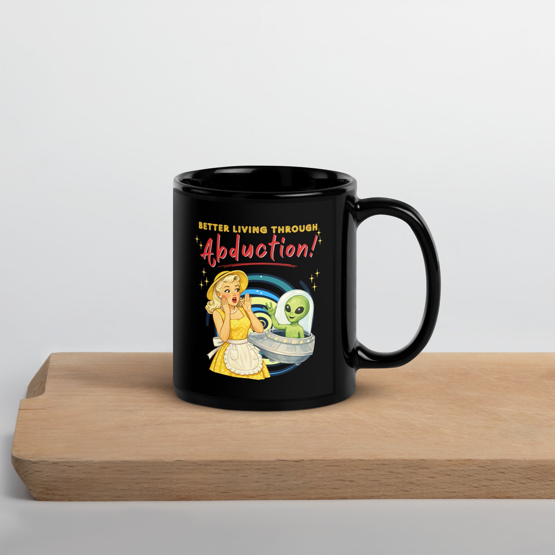 Better Living Through Abduction black ceramic mug — vintage 1950s retro blonde housewife in yellow polka dot dress reacting with delight to a friendly green alien waving from a silver saucer, printed on both sides by Cinderpoint Studios