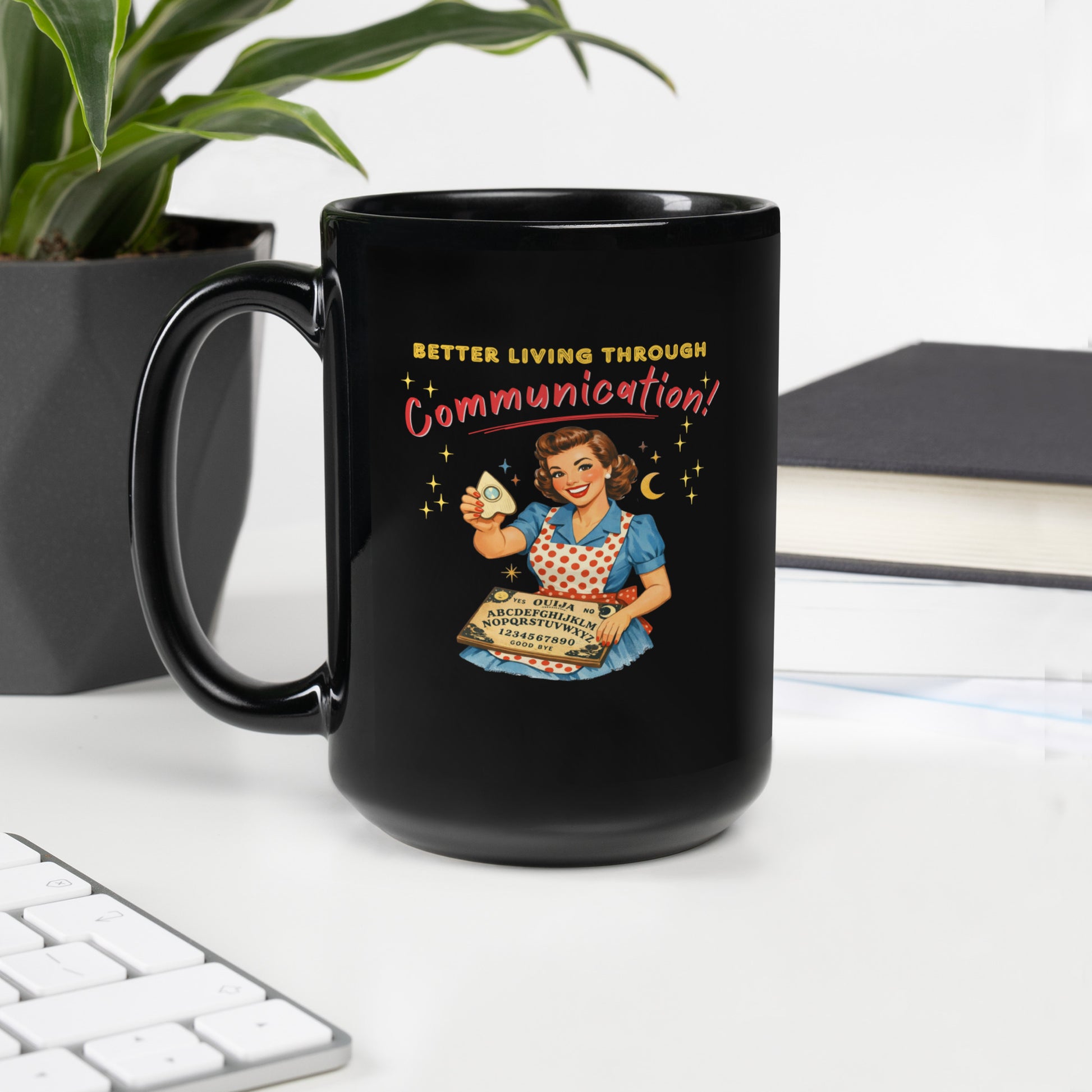 Better Living Through Communication black ceramic mug — vintage 1950s retro housewife in polka dot apron holding ouija board and planchette, printed on both sides by Cinderpoint Studios
