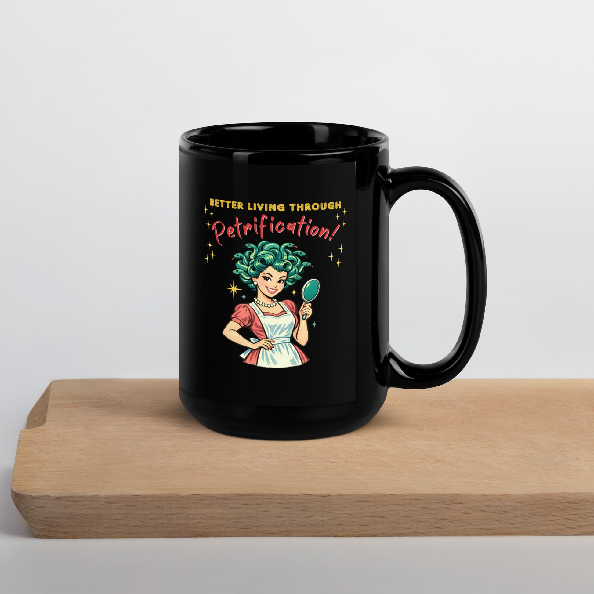 Better Living Through Petrification black ceramic mug — vintage 1950s retro Medusa housewife with styled snake hair holding a hand mirror and smiling confidently in pearls and apron, printed on both sides by Cinderpoint Studios