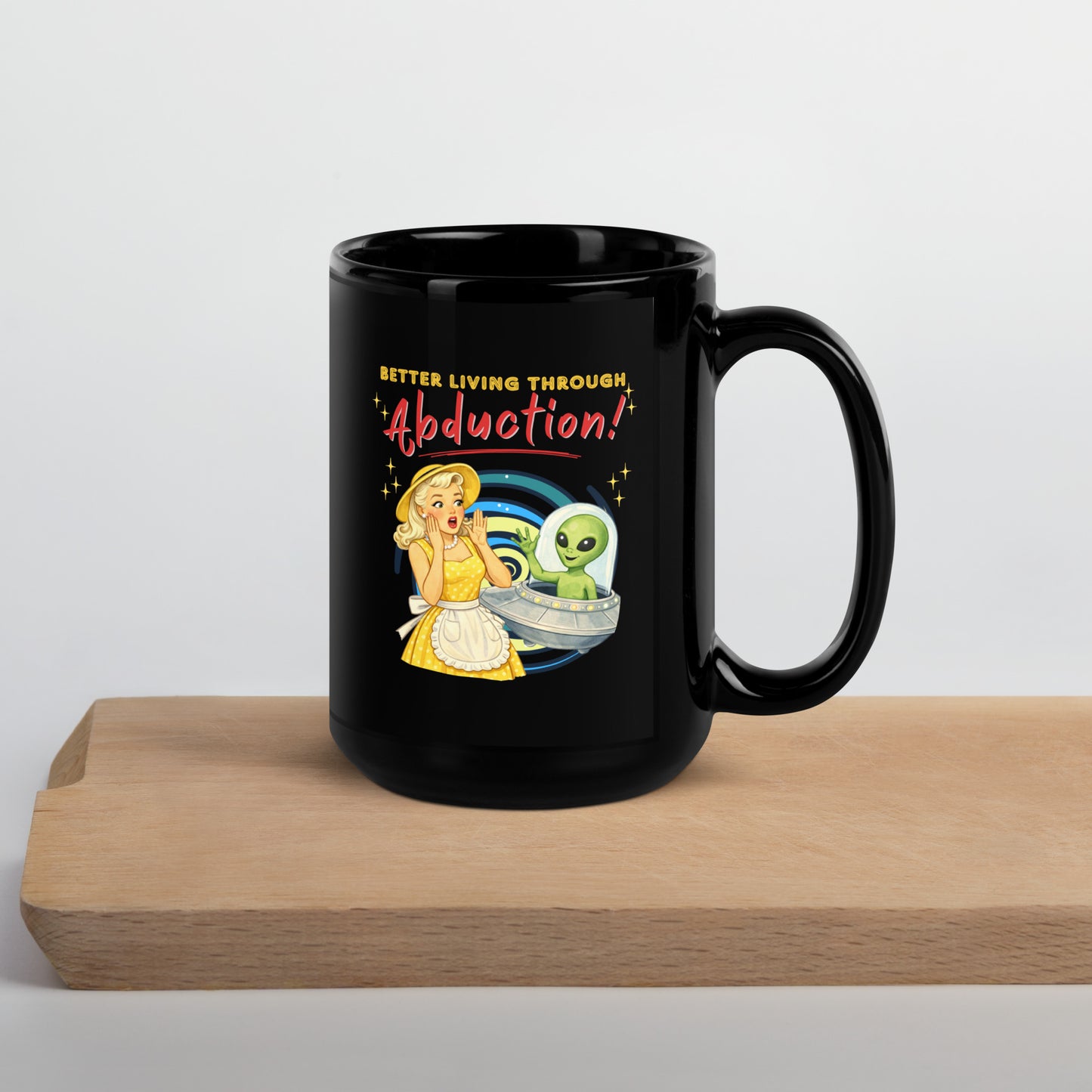 Better Living Through Abduction black ceramic mug — vintage 1950s retro blonde housewife in yellow polka dot dress reacting with delight to a friendly green alien waving from a silver saucer, printed on both sides by Cinderpoint Studios