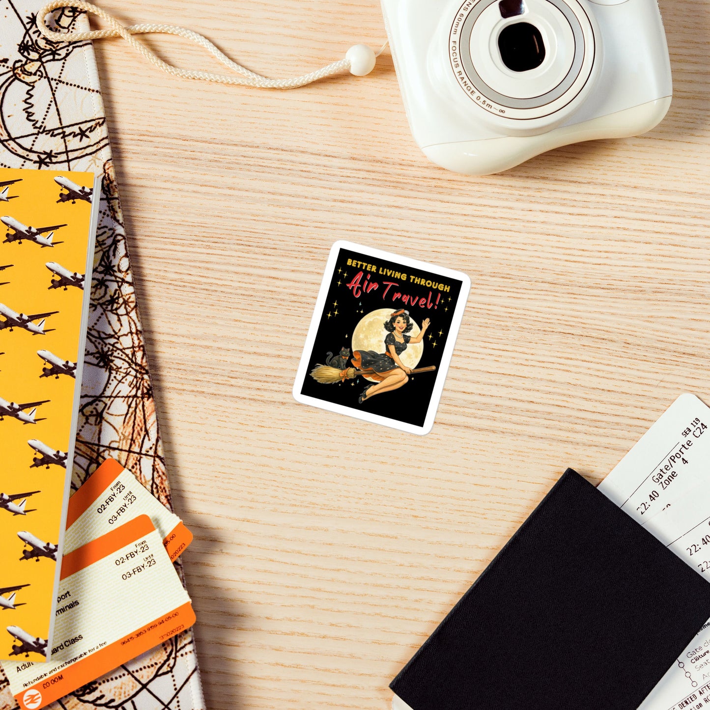 Better Living Through Air Travel vinyl decal — vintage retro pinup witch in black polka dot dress and stewardess hat riding a broom in front of a full moon with dapper black cat familiar in orange bow tie on black background, satin finish waterproof sticker by Cinderpoint Studios
